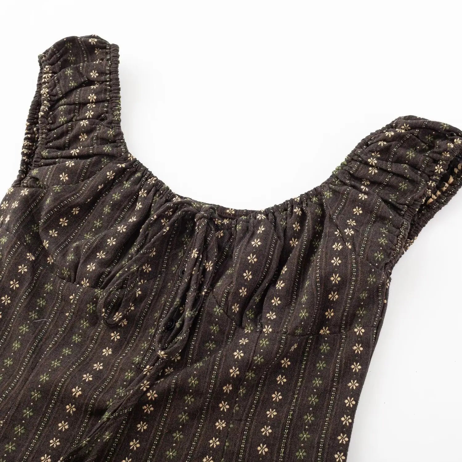 Dark brown vertical floral top square neck flat lay detail, full elastic ruched cap sleeve straps and gathered neckline stitching