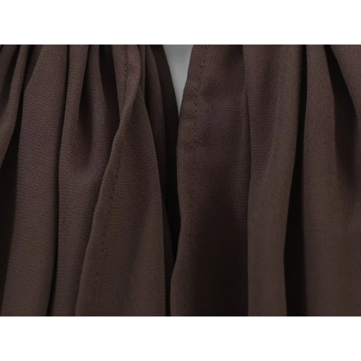 Macro of sheer lightweight chiffon fabric, dense vertical gathering folds, soft matte non-sheer brown chiffon texture