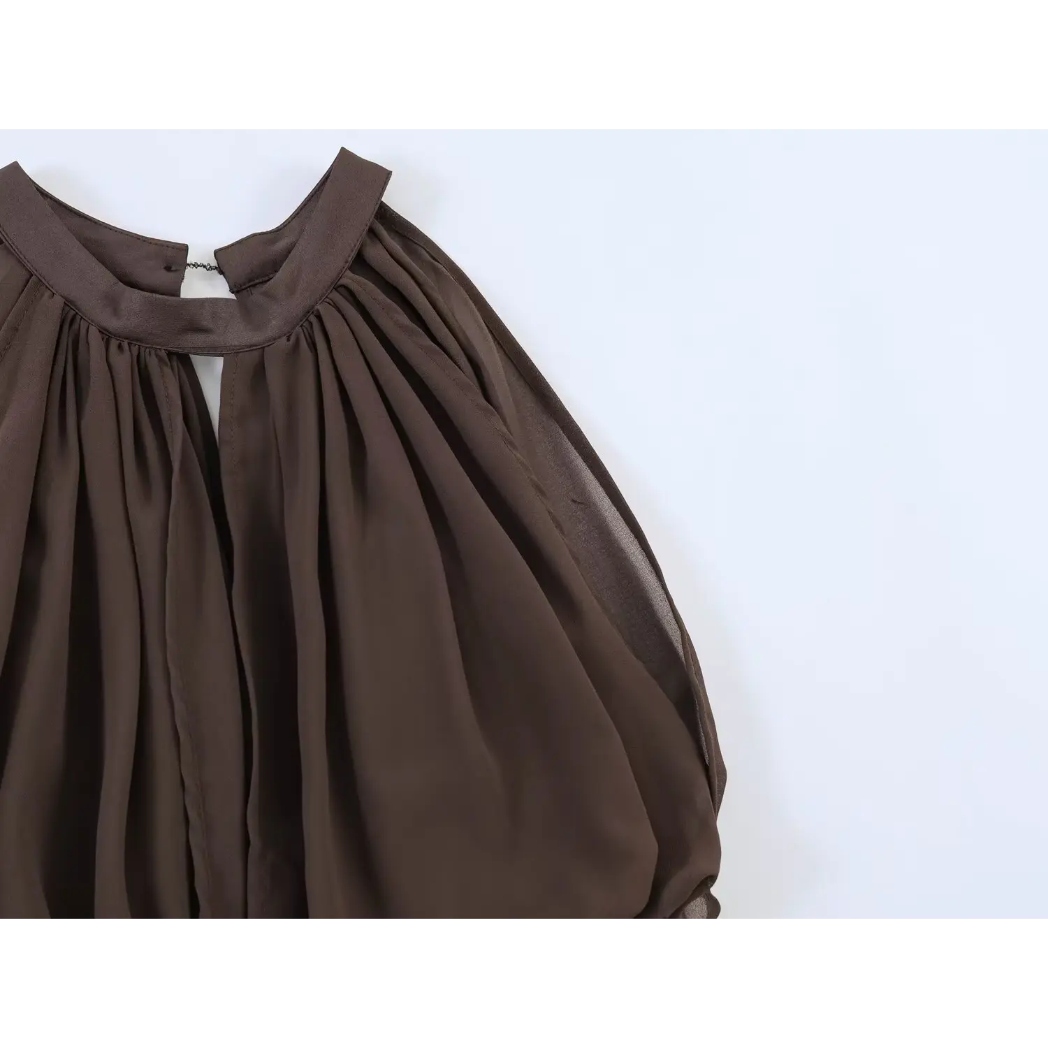 Partial neck close-up, stand halter band, small keyhole opening with hook clasp, dense gathered chiffon overlay forming bubble blouson effect