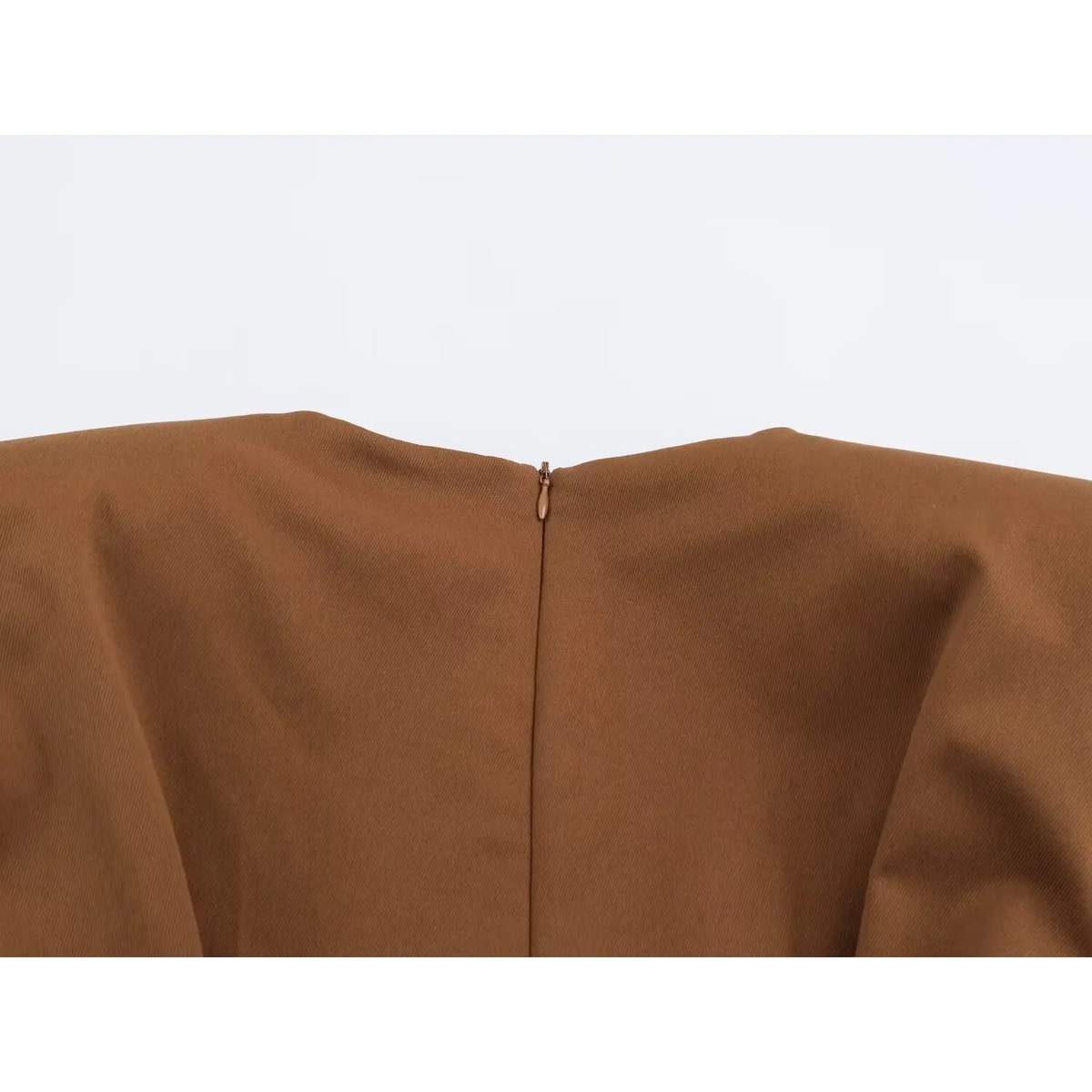 Close-up of back zipper detail on brown dress with matching zipper pull