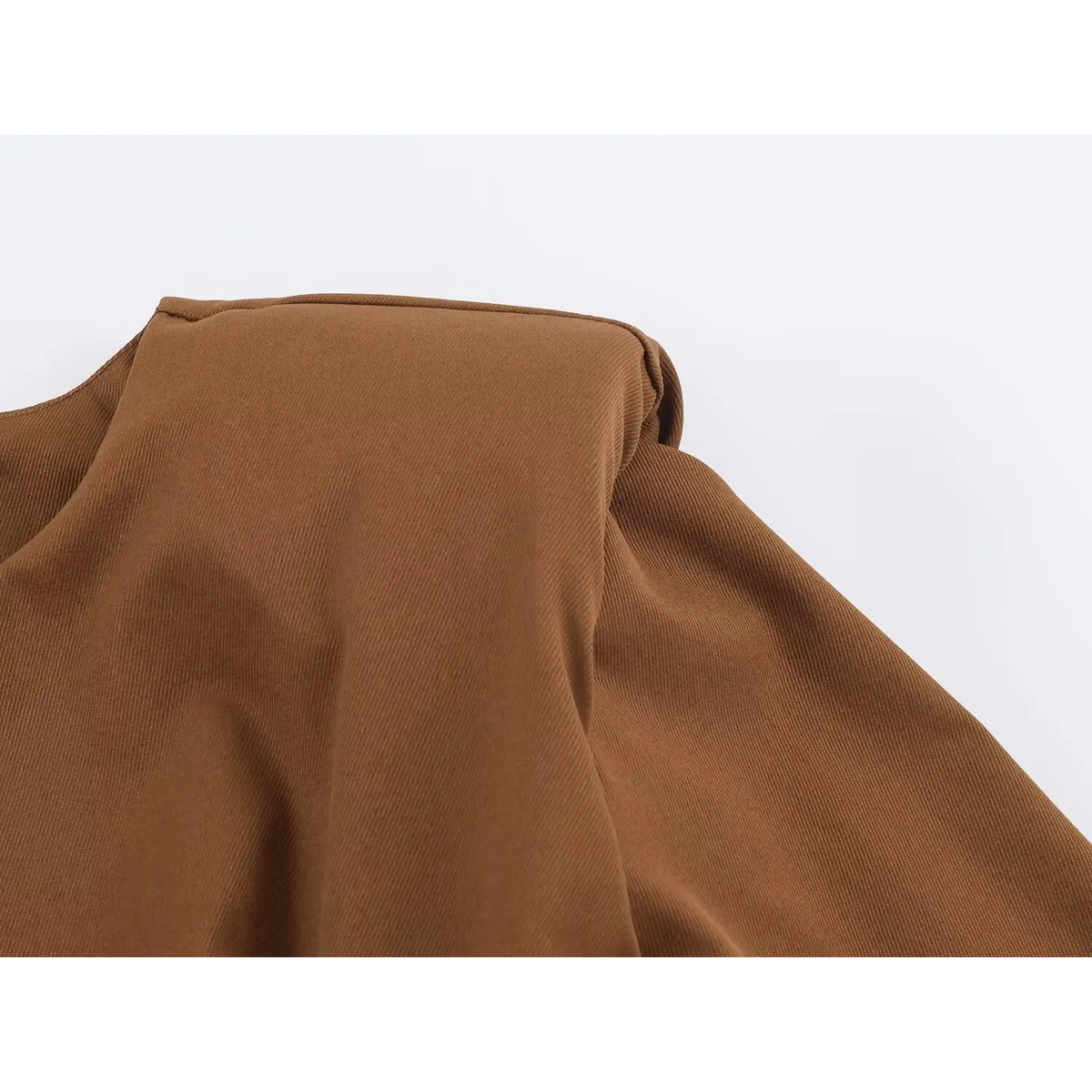 Close-up of caramel brown twill fabric texture with soft folds
