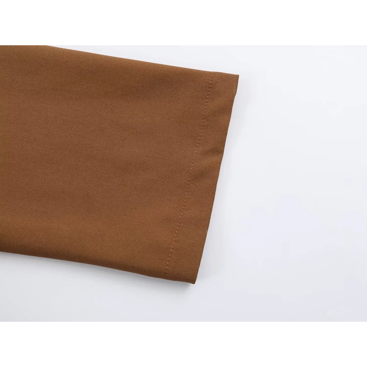 Close-up of brown twill fabric edge with fine stitching