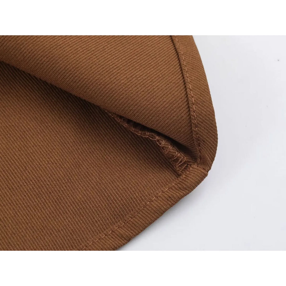 Close-up of brown twill fabric folded corner showing seam lines