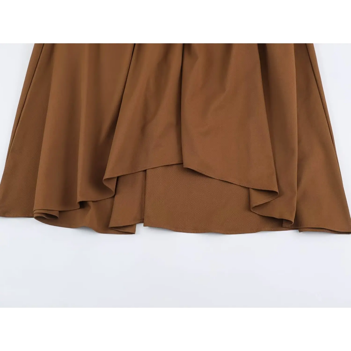 Detail of layered ruffle hem of brown dress with soft pleats