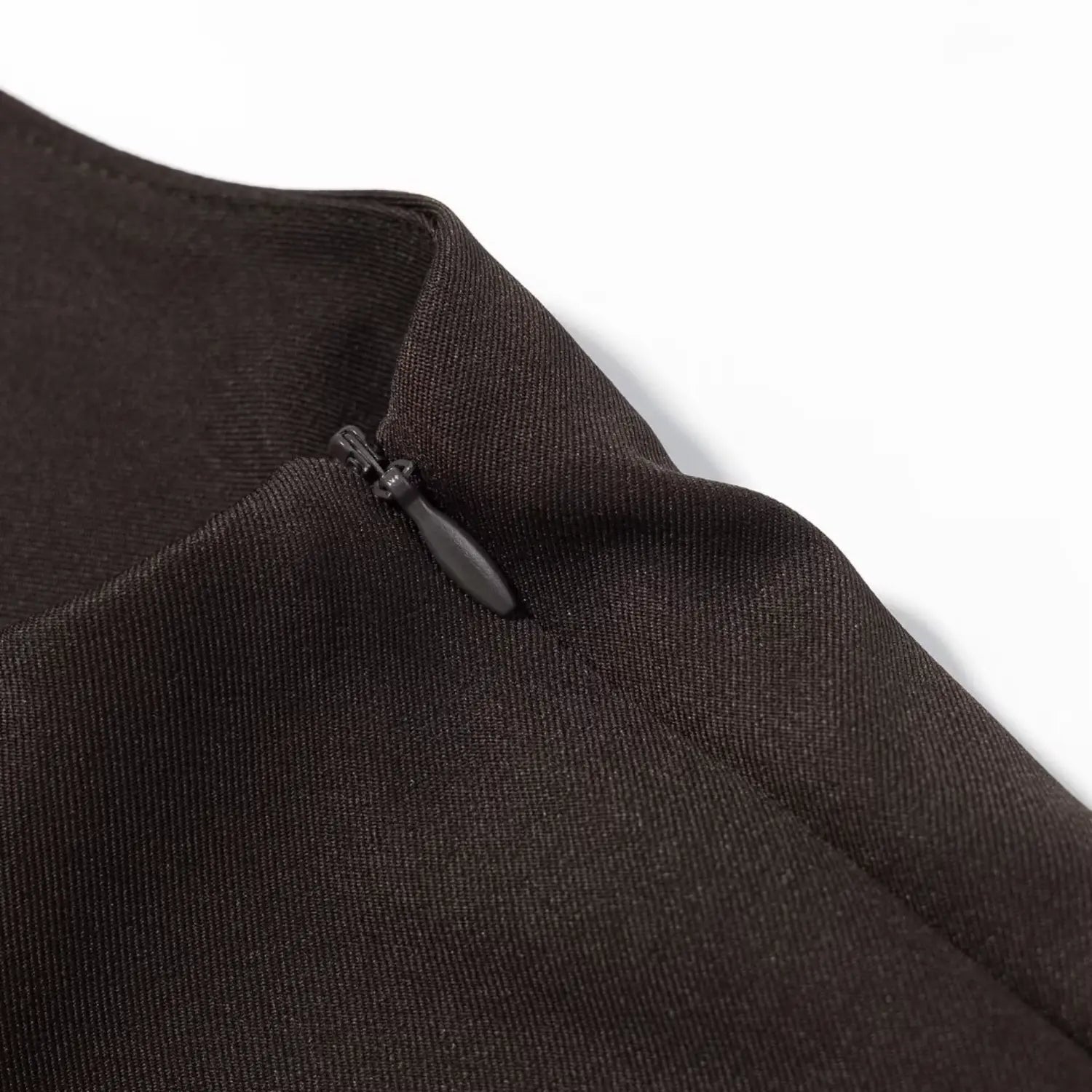 Close‑up of invisible side zipper on dark brown sleeveless mini dress