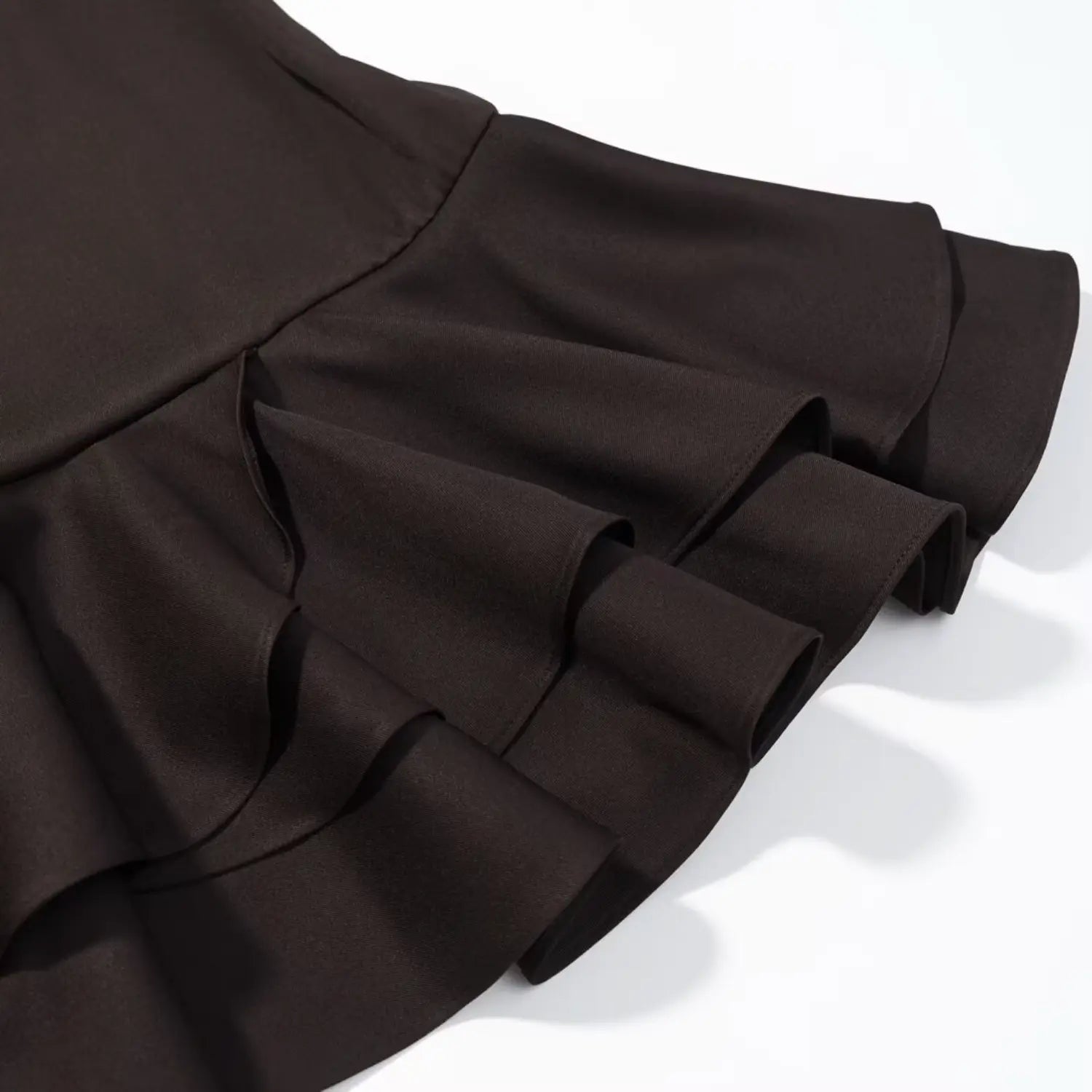 Detailed shot of double‑layer tiered ruffle hem of dark brown mini dress