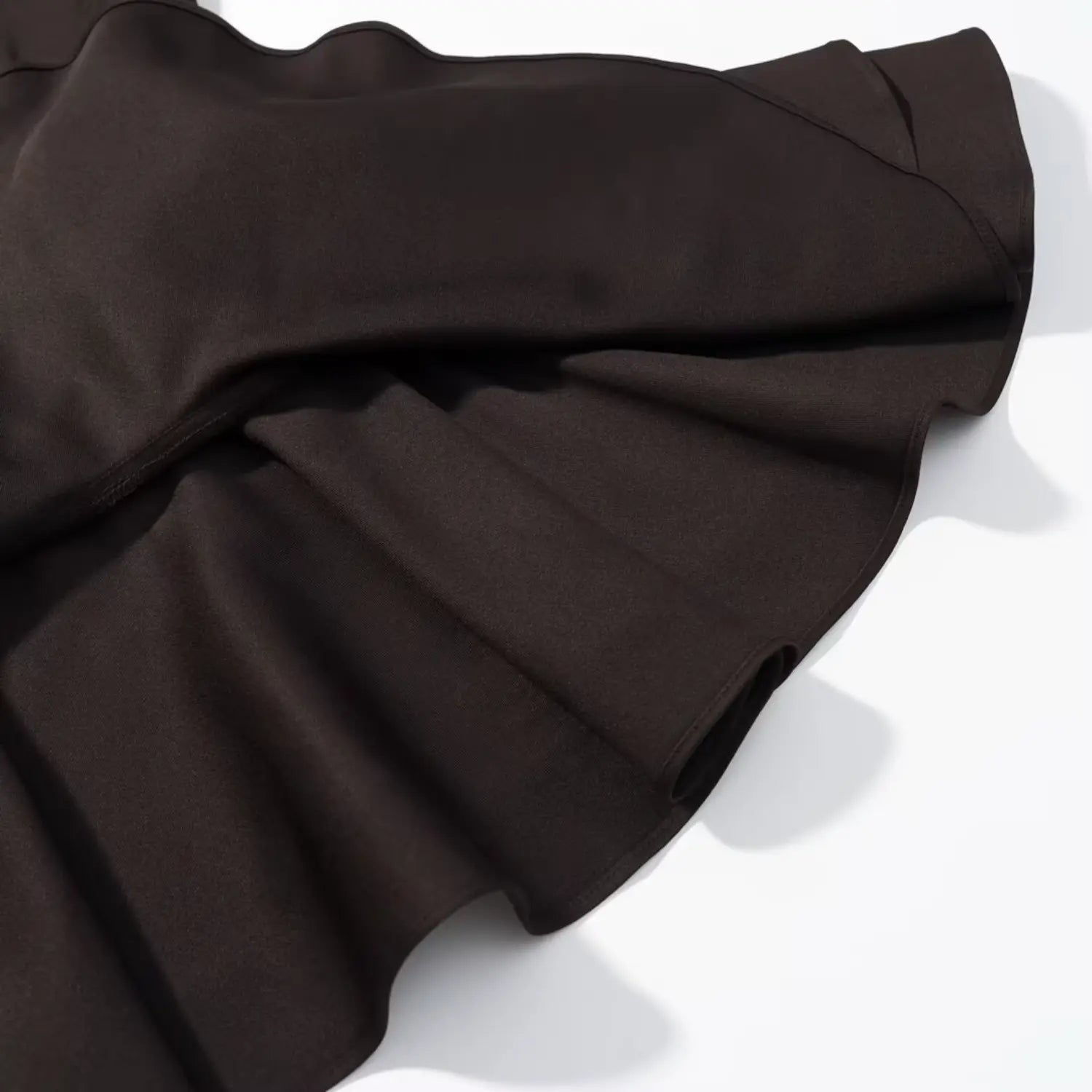 Folded fabric detail of layered ruffle skirt hem for dark brown sleeveless dress