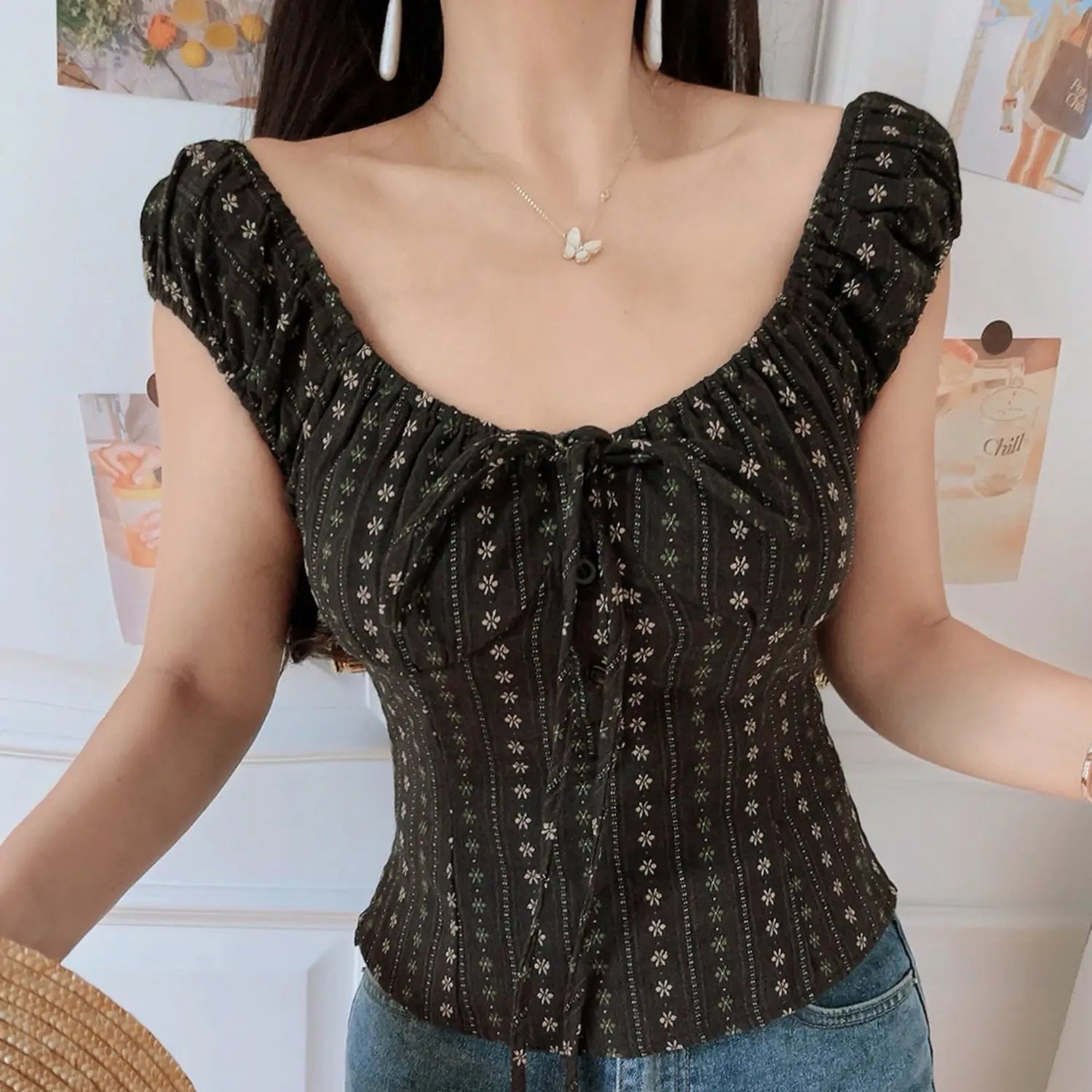 Women vintage dark brown tiny floral square neck crop top, ruched puff sleeve button front tie detail, model shot against white wall