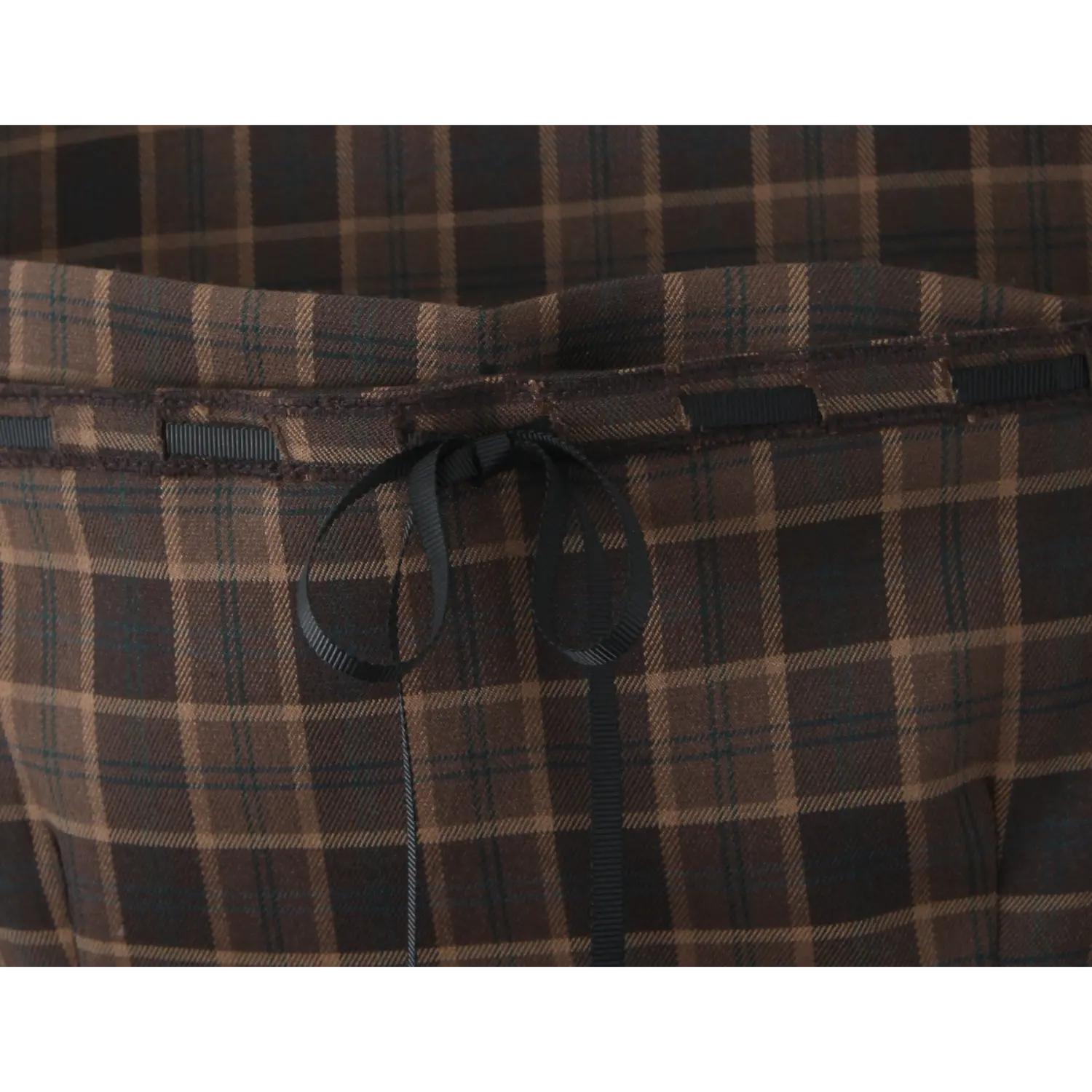 Close-up of back waist panel, matching plaid woven fabric, horizontal black ribbed ribbon strip, adjustable self-fabric ribbon bow tie, neat serged seam edges