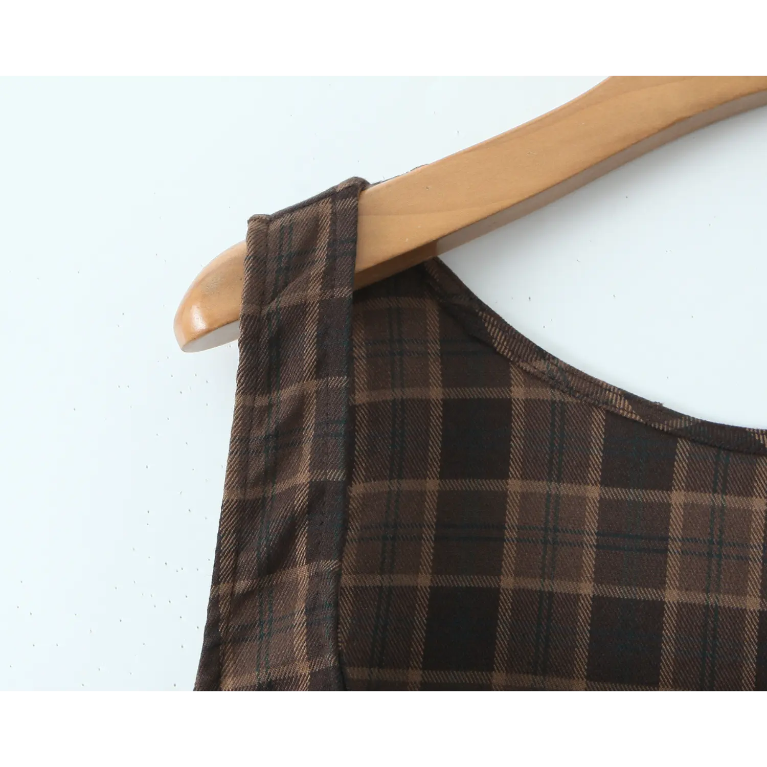 Flat close-up of wide integrated plaid shoulder strap and round scoop neck, clean folded binding hem, twill woven plaid texture