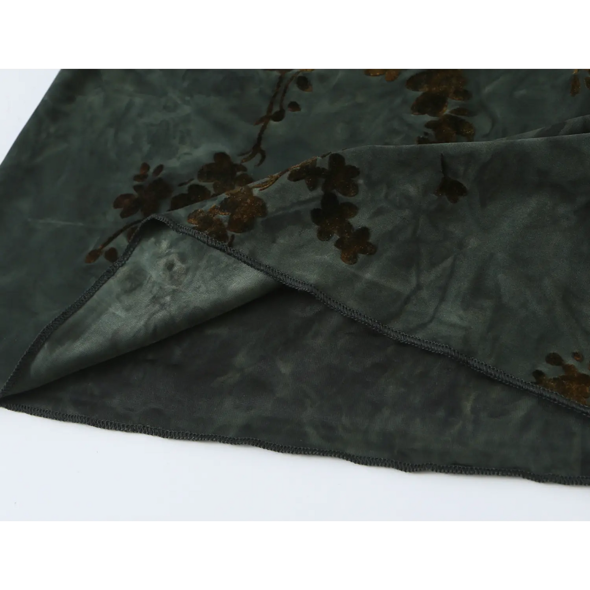 Close‑up of sheer hem, dark green chiffon layers and brown floral print