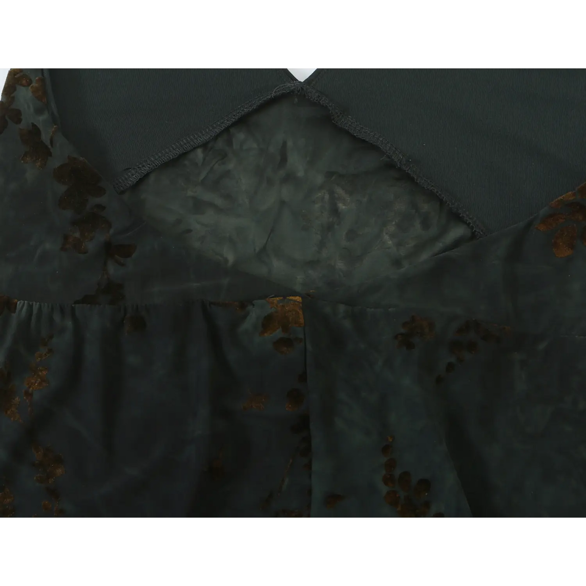 Close‑up of solid dark green inner lining and sheer floral overlay at bodice