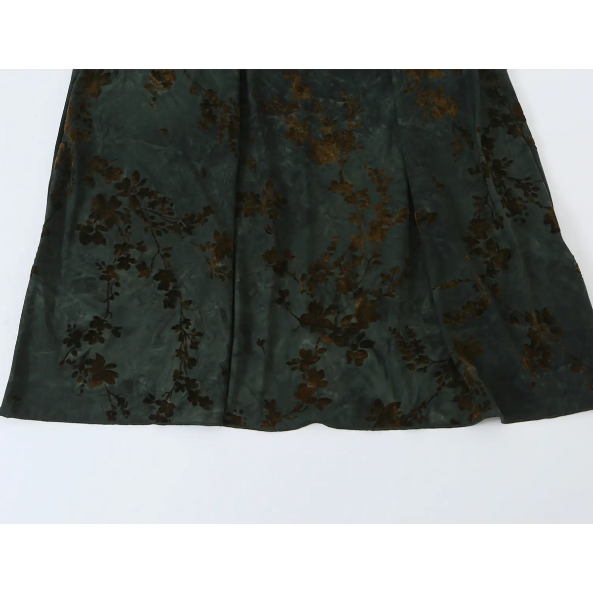 Partial view of flowy long skirt, dark green floral pattern and soft fabric drape