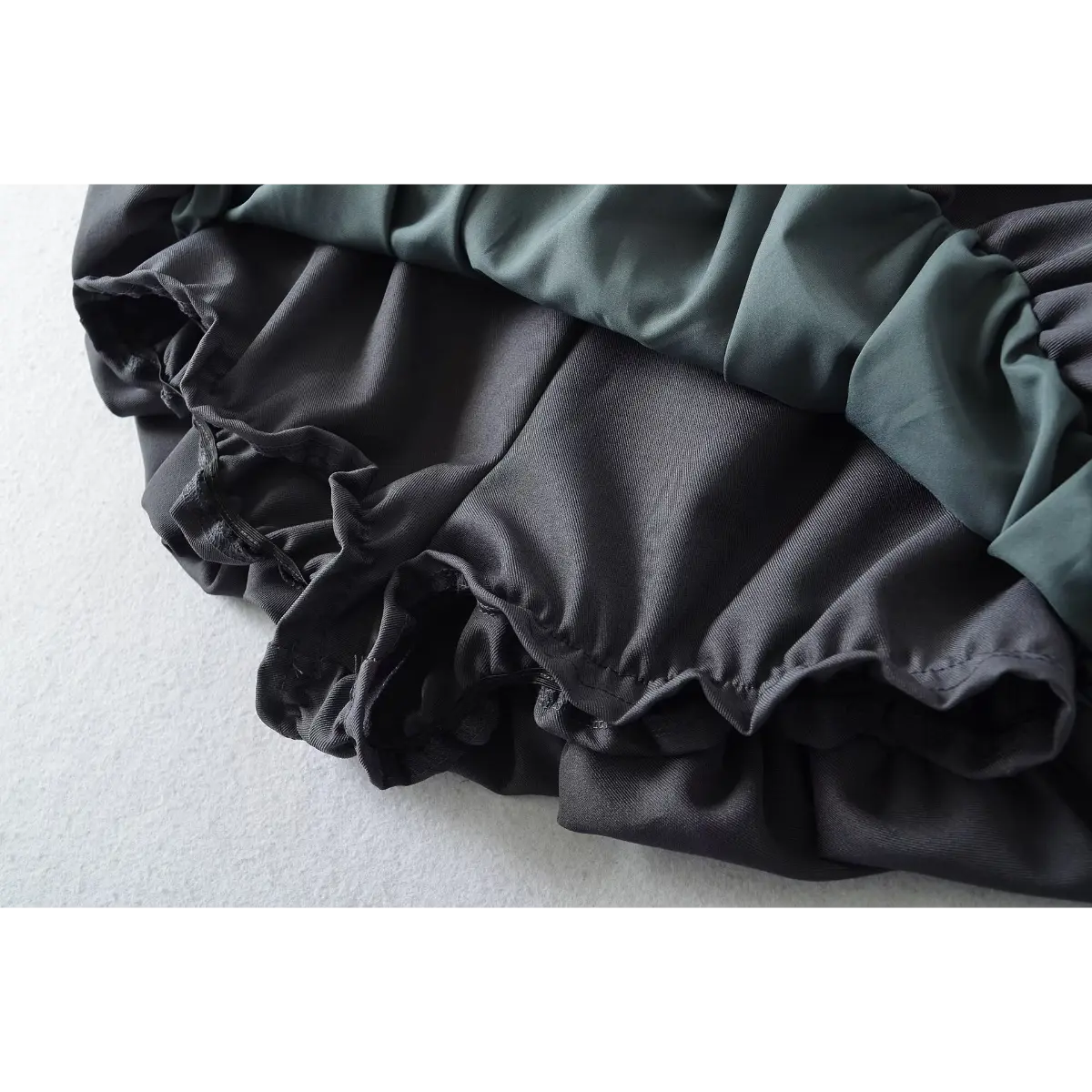 Close-up of the ruffled hem and built-in lining on the dark grey bubble mini skirt