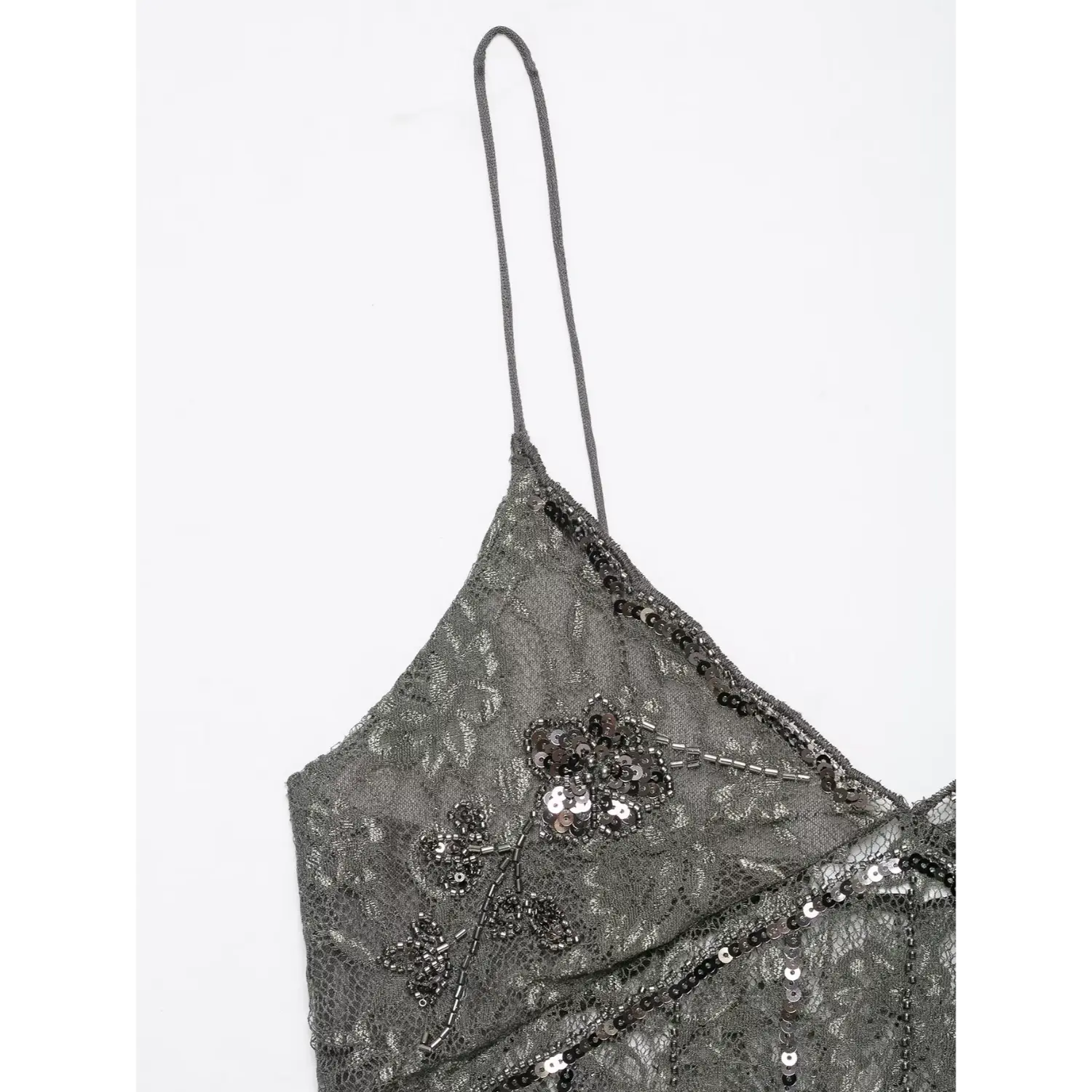 Close‑up shoulder view thin spaghetti strap and floral sequin beadwork on dark grey lace cami