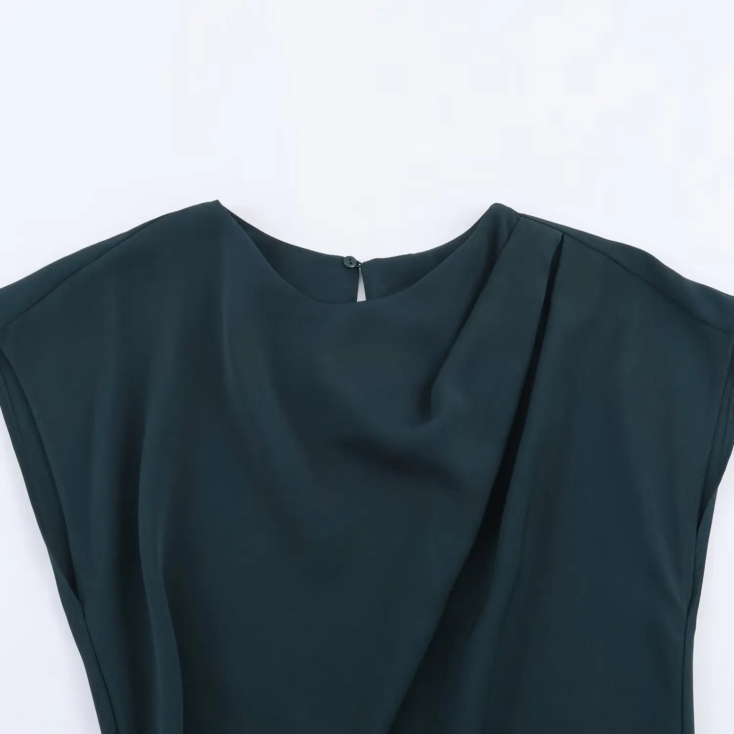 Close‑up shot of draped cowl neckline, dark teal smooth woven fabric, back keyhole button detail, cap shoulder seam