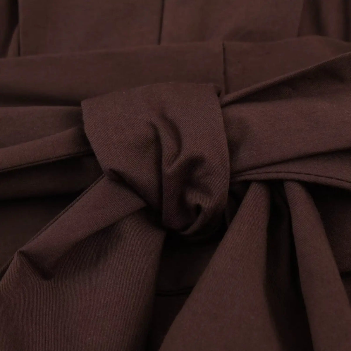 Close‑up of fabric waist tie bow knot detail