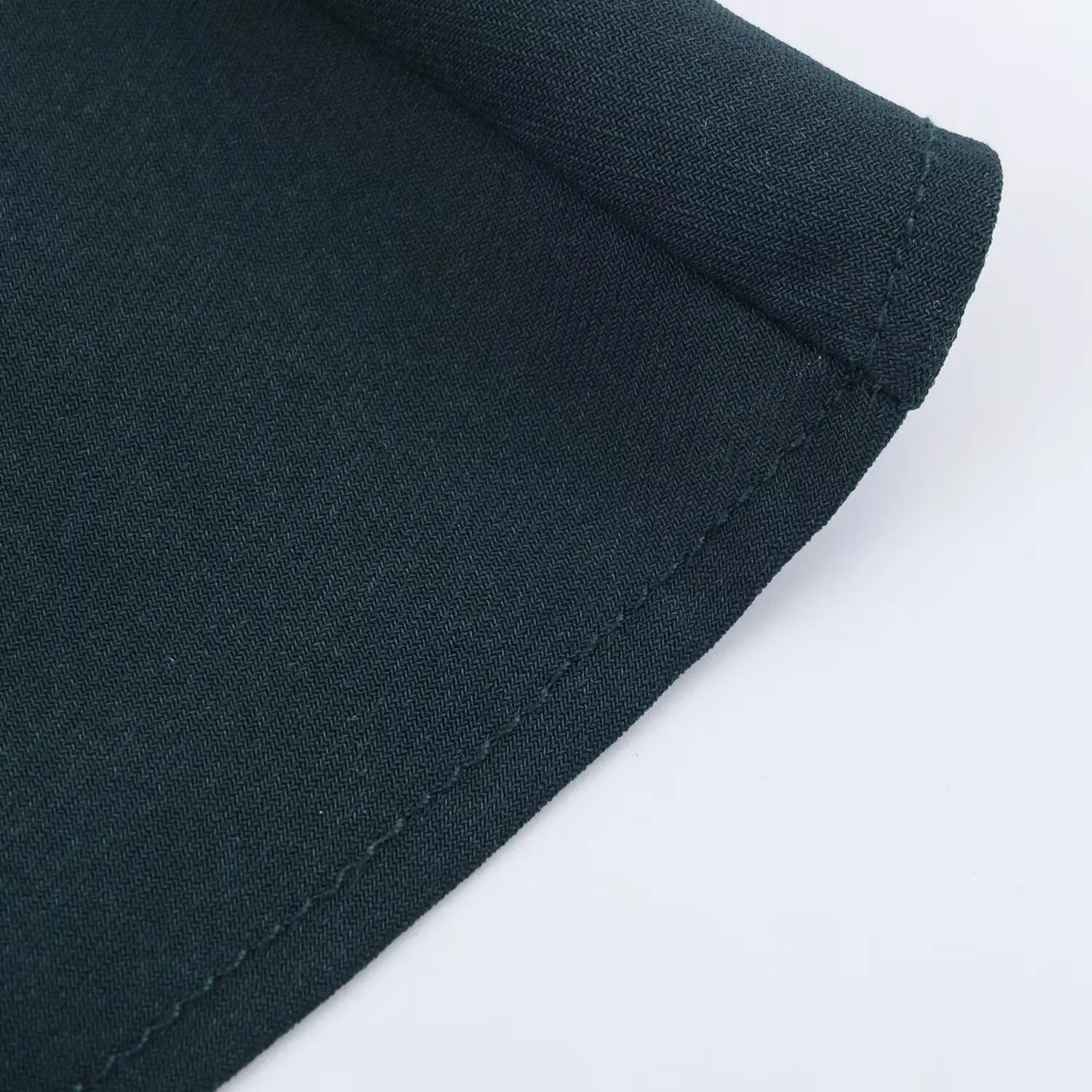 Close‑up of finished bottom hem of dark green color‑block maxi dress
