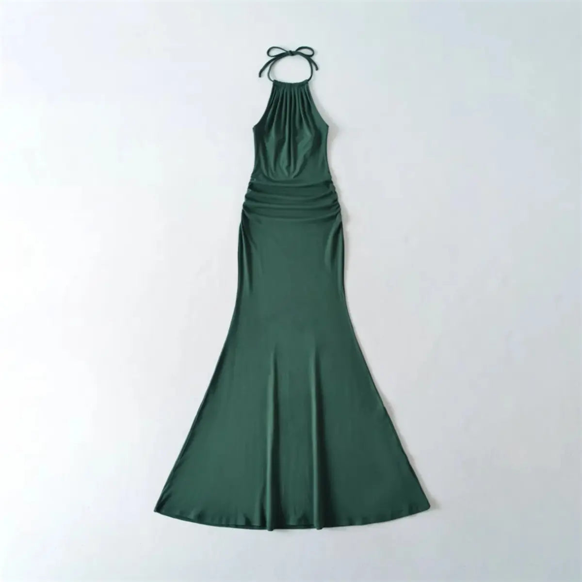  Flat lay view of a deep green halter-neck mermaid maxi dress, showing the full form-fitting silhouette and tied halter straps.