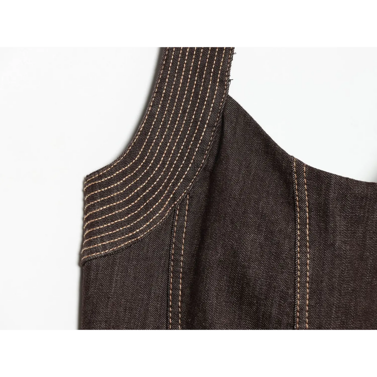 Macro shot of shoulder part, decorative contrast topstitching on dark brown halter denim dress