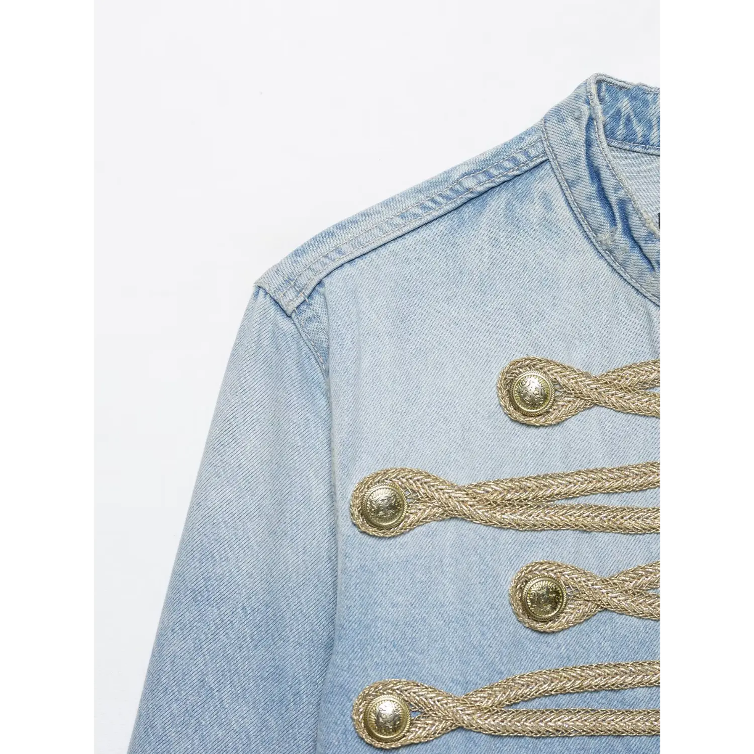 Close-up shot gold braided cord & vintage metal buttons on light wash military denim jacket front panel