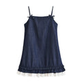 Flat lay front view of dark denim spaghetti strap mini dress with shoulder bow ties and double ruffle hem with white under‑layer, white background
