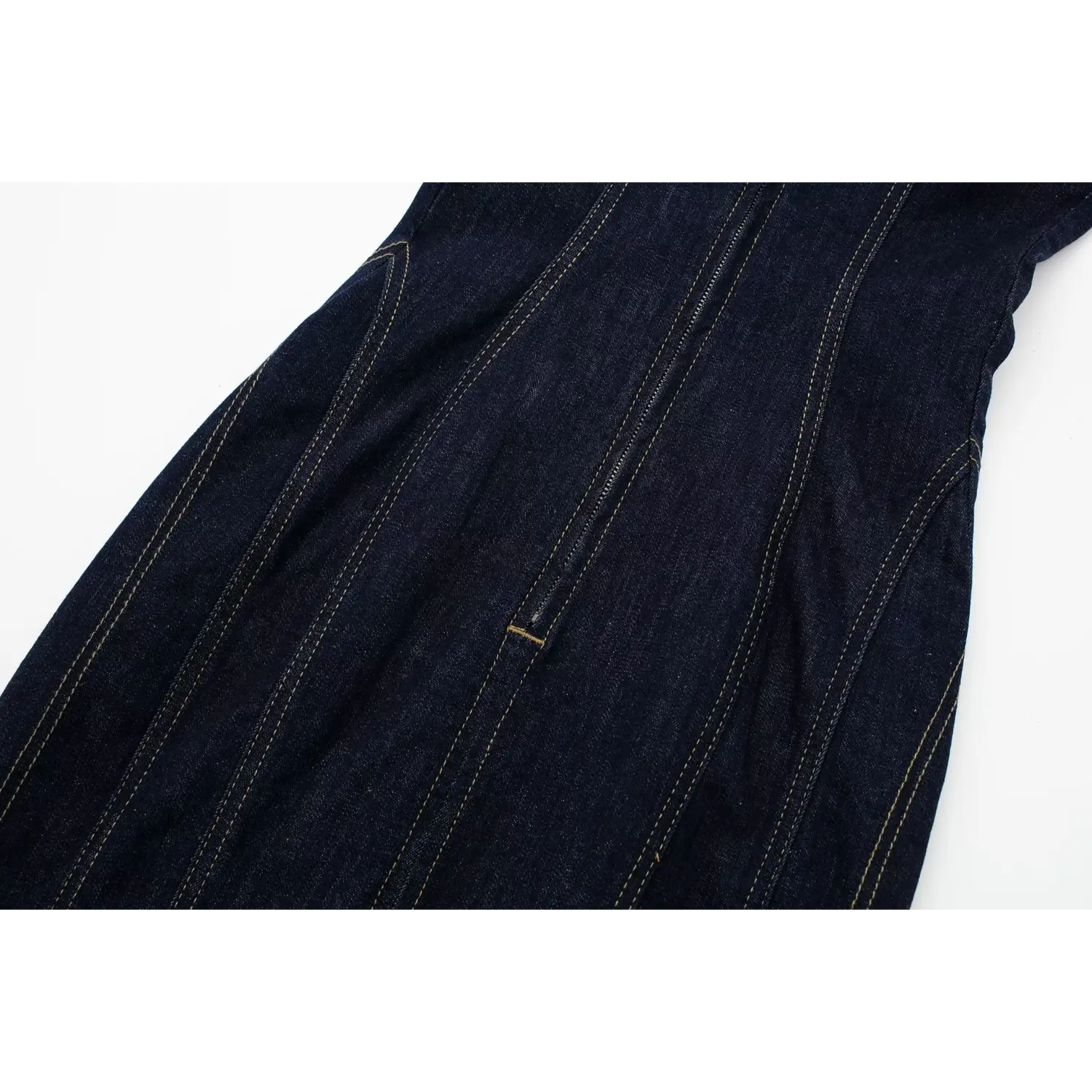 Side close‑up of central back metal zipper and contour seaming on dark strapless denim midi dress