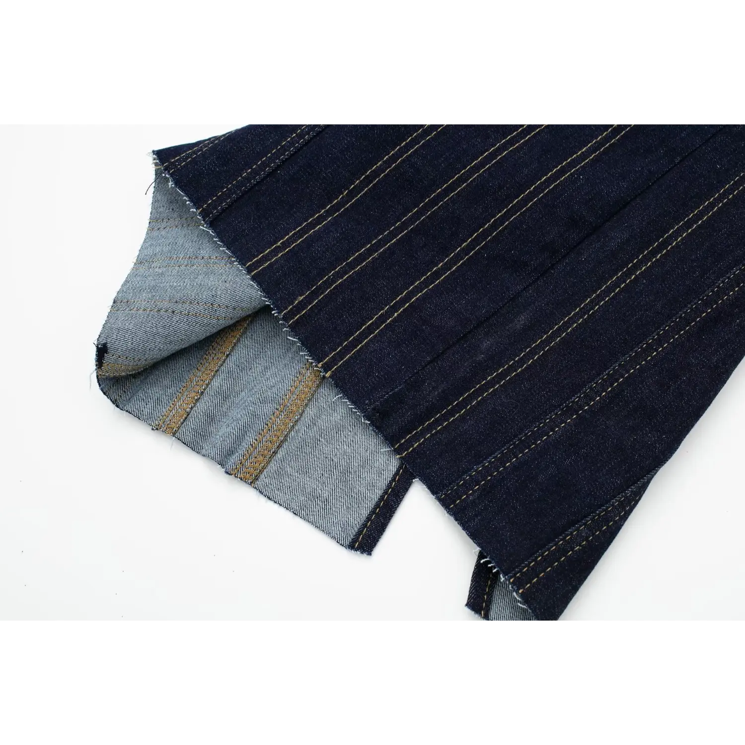 Close‑up of dress hem, showing denim reverse inner fabric and heavy yellow stitched seam construction