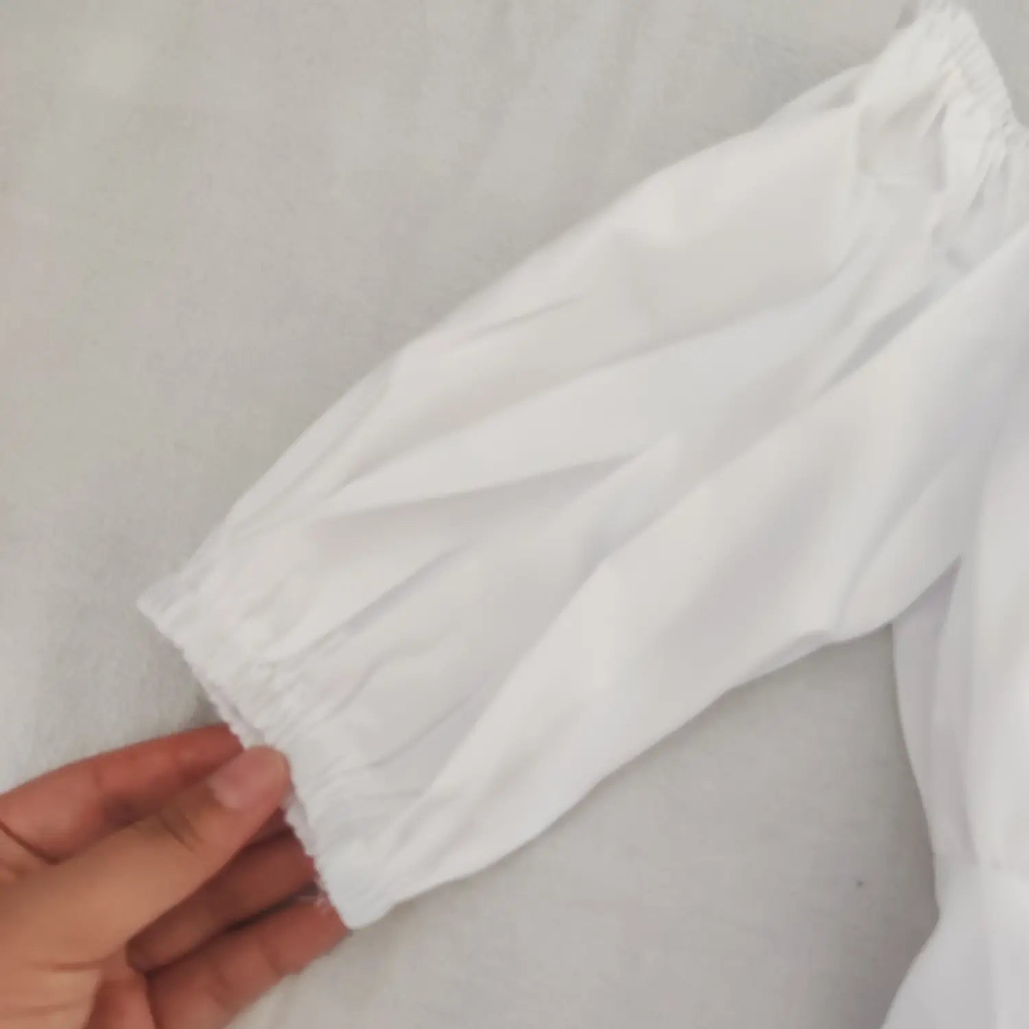 Detail shot elastic gathered cuff on short puff sleeve white off shoulder top