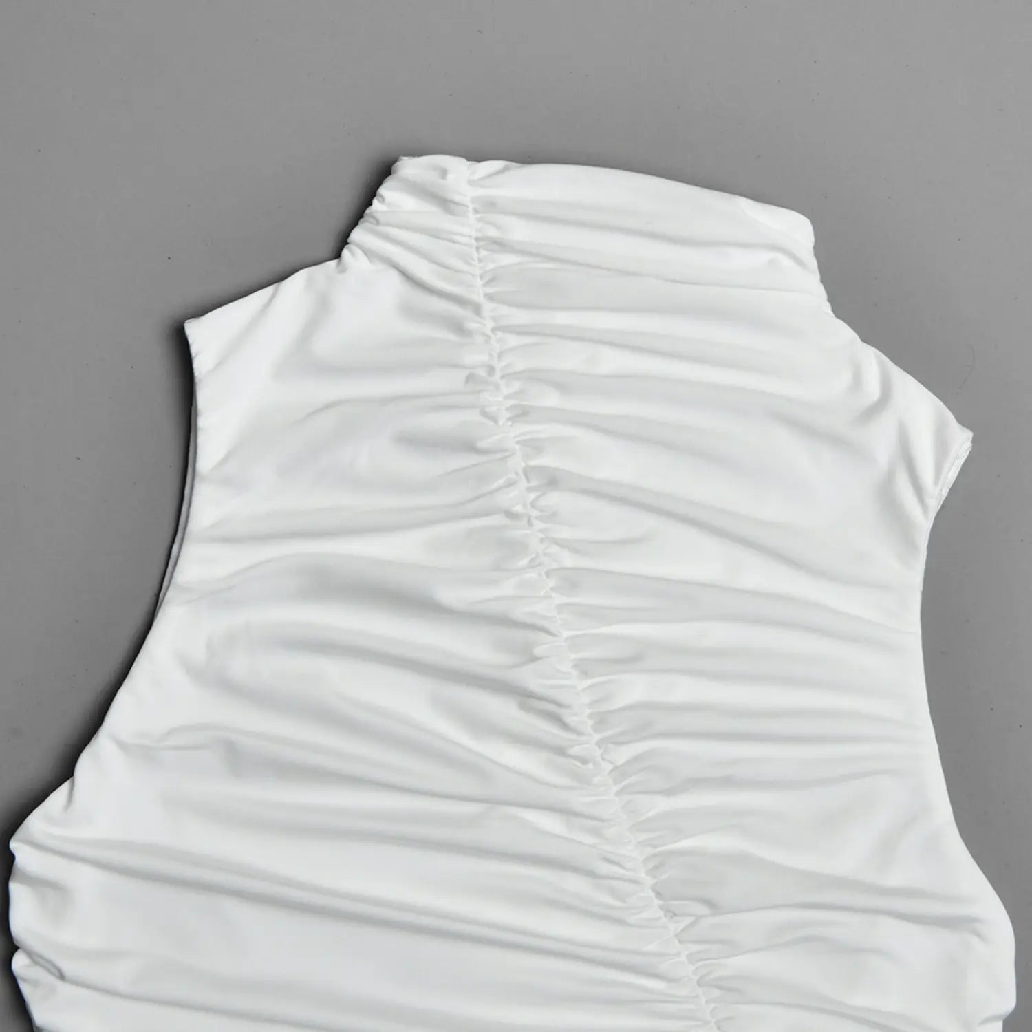 Close-up detail of diagonal ruched chest fabric on white sleeveless high neck dress