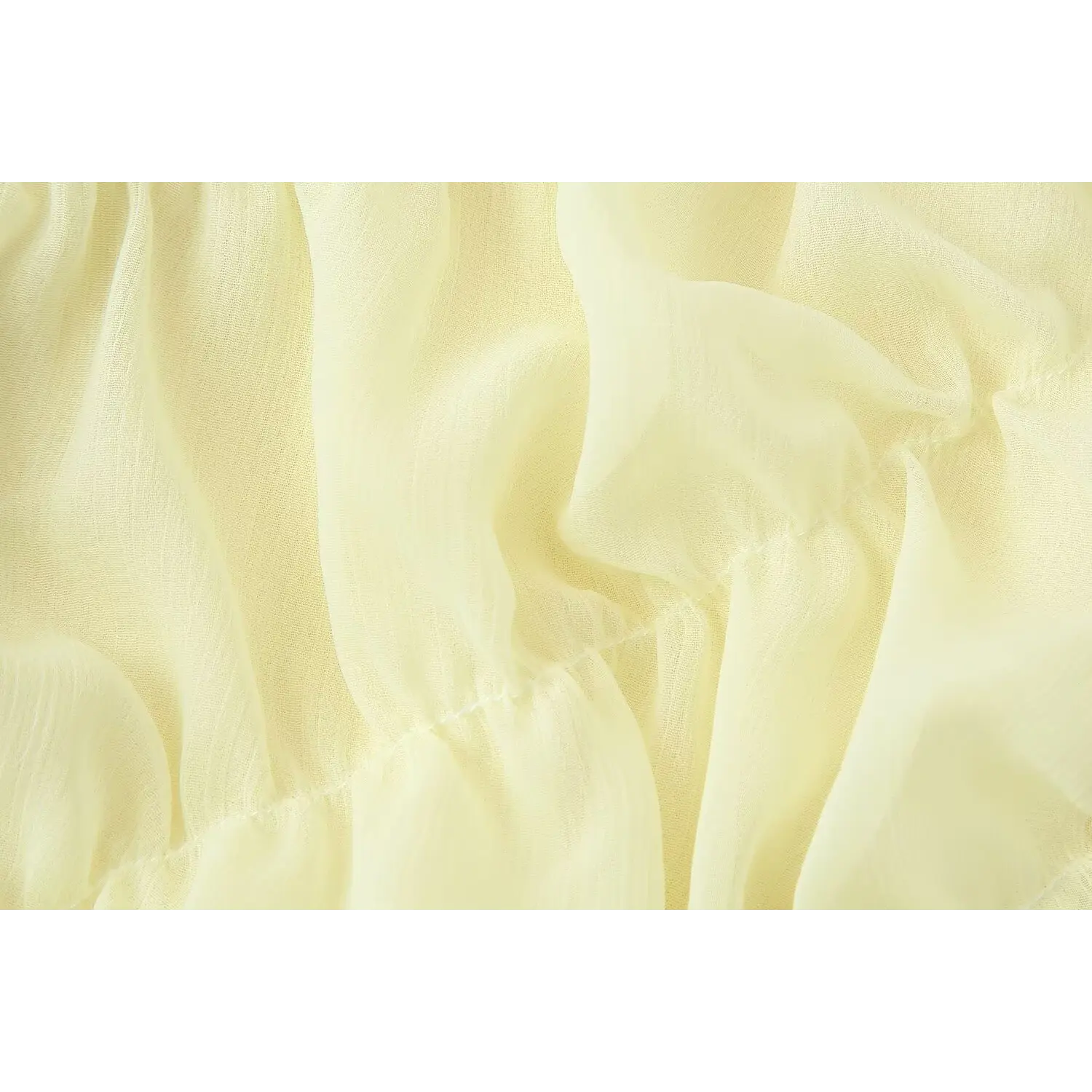 Macro close-up diagonal stitched ruched seam on pale yellow vertical grain chiffon, natural wrinkled sheer fabric texture