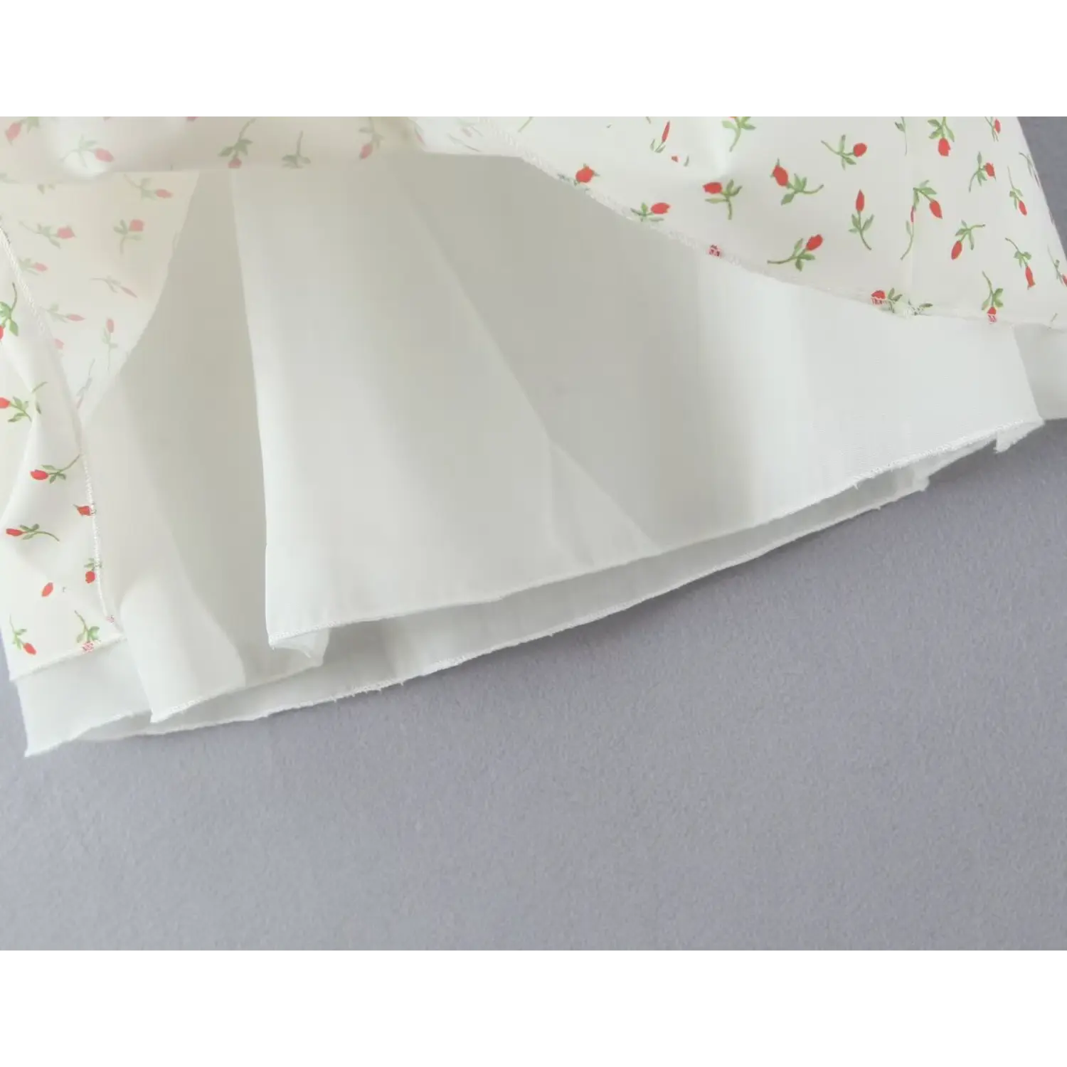 Close‑up flipped skirt showing solid white inner lining fabric construction seam details