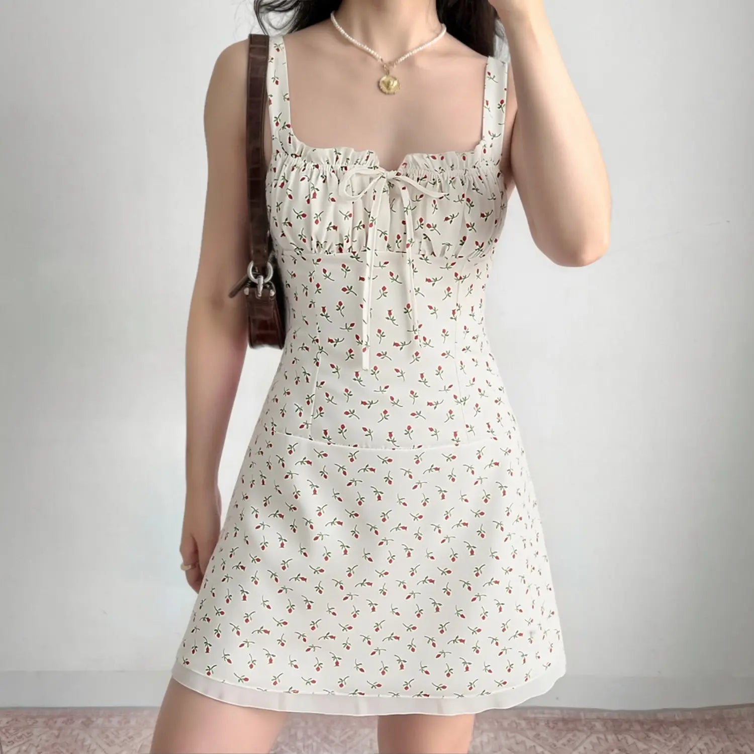 Indoor model wearing shot white ditsy floral cami mini dress fitted bodice a‑line skirt casual styling