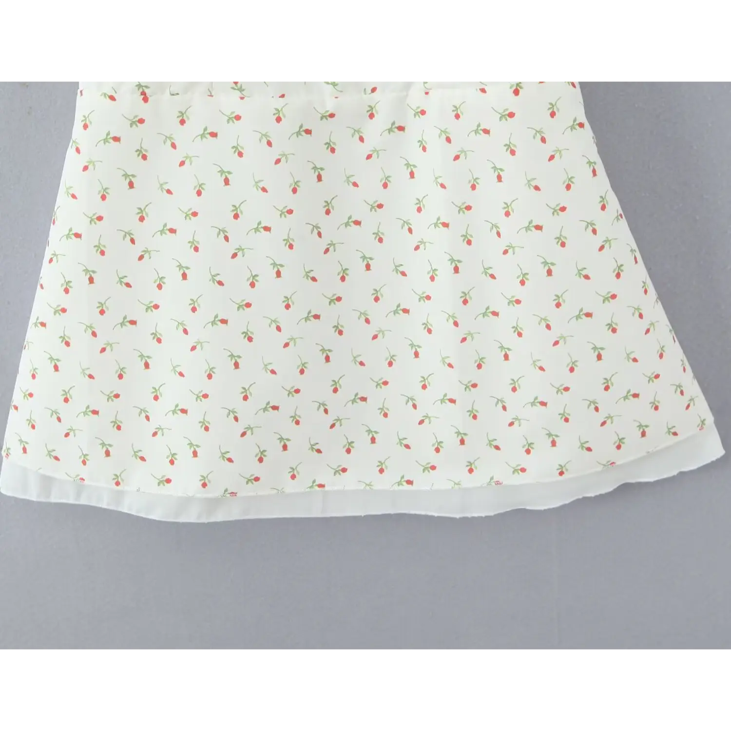 Close‑up flared a‑line skirt hem with sheer inner lining white floral cami dress finished edge