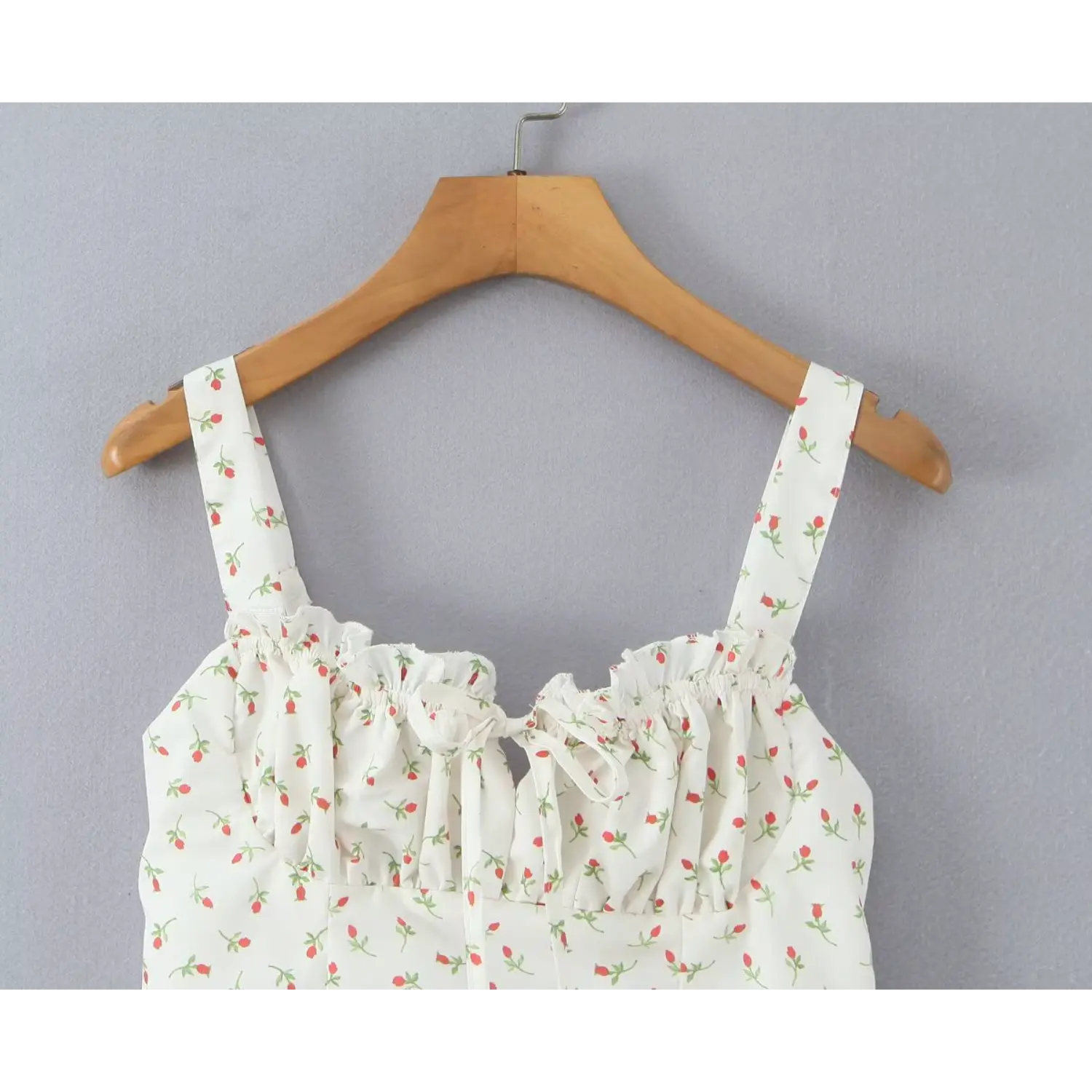 Close‑up wide shoulder strap and ruffled elastic bust white ditsy rose bud print cami dress front tie detail