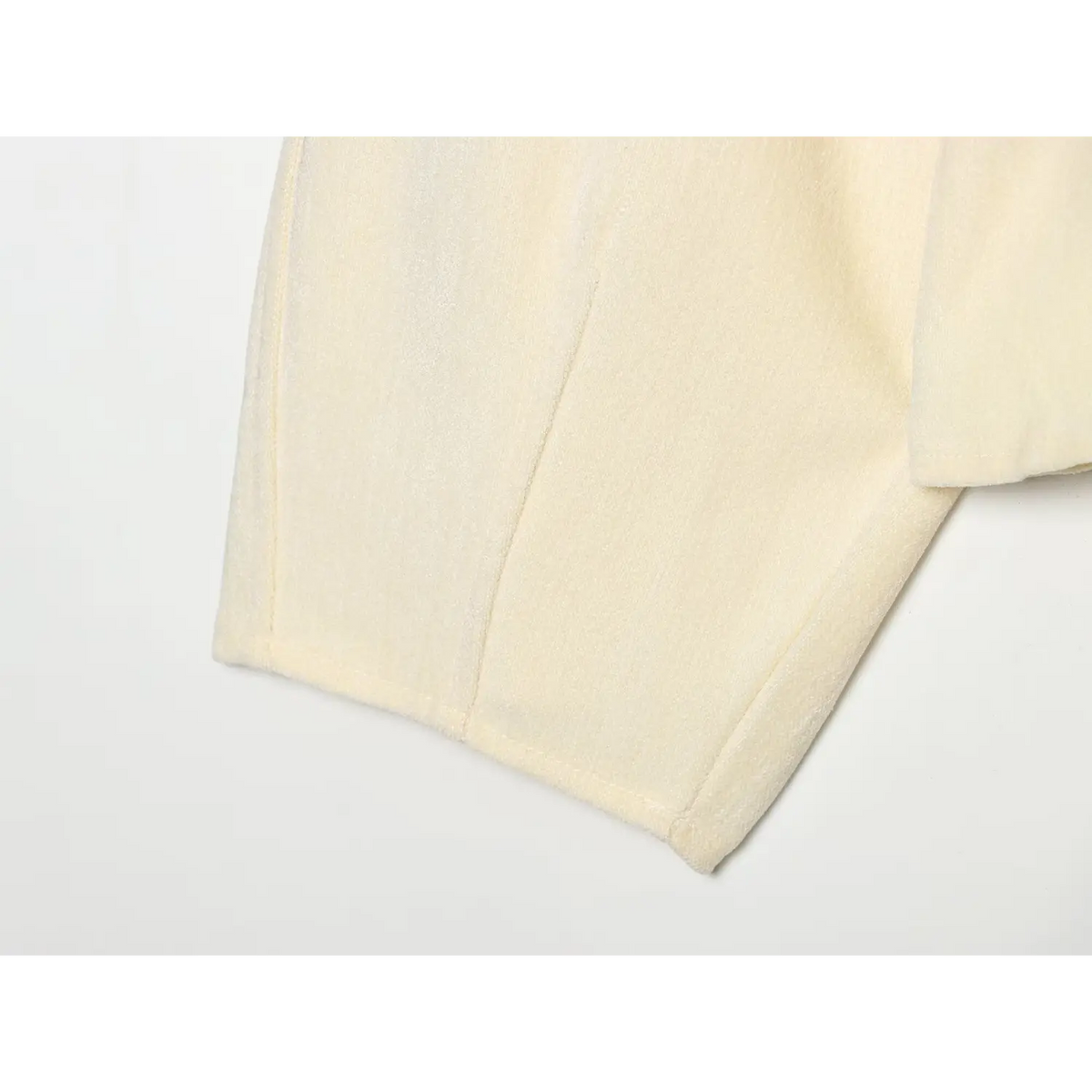 Close-up of cream hem and side seam