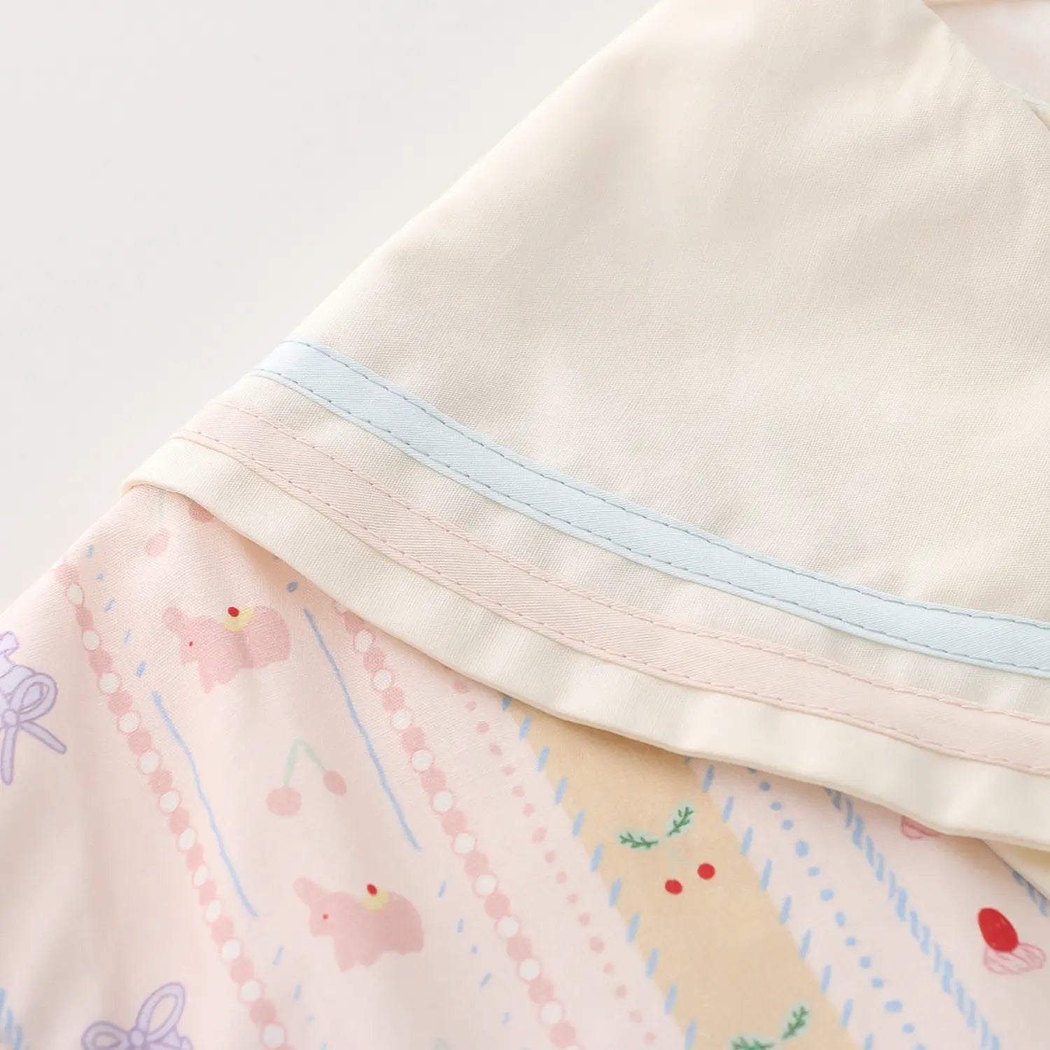Double layer wide sailor lapel contrast piping macro close-up, cream lapel with light blue & pink double thin piping trim smooth splicing stitching wrinkle free neck layered craft detail shot