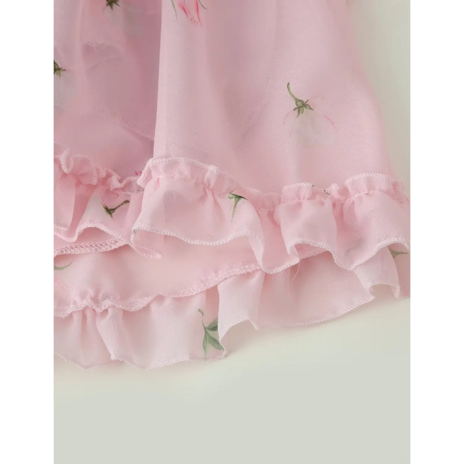 Bottom skirt hem macro shot, two-tier cascading ruffle layers, soft crinkled chiffon with mini rose print
