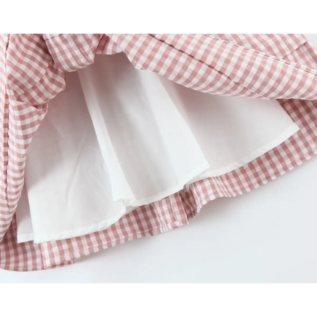 Inner solid lining layer under outer gingham skirt hem