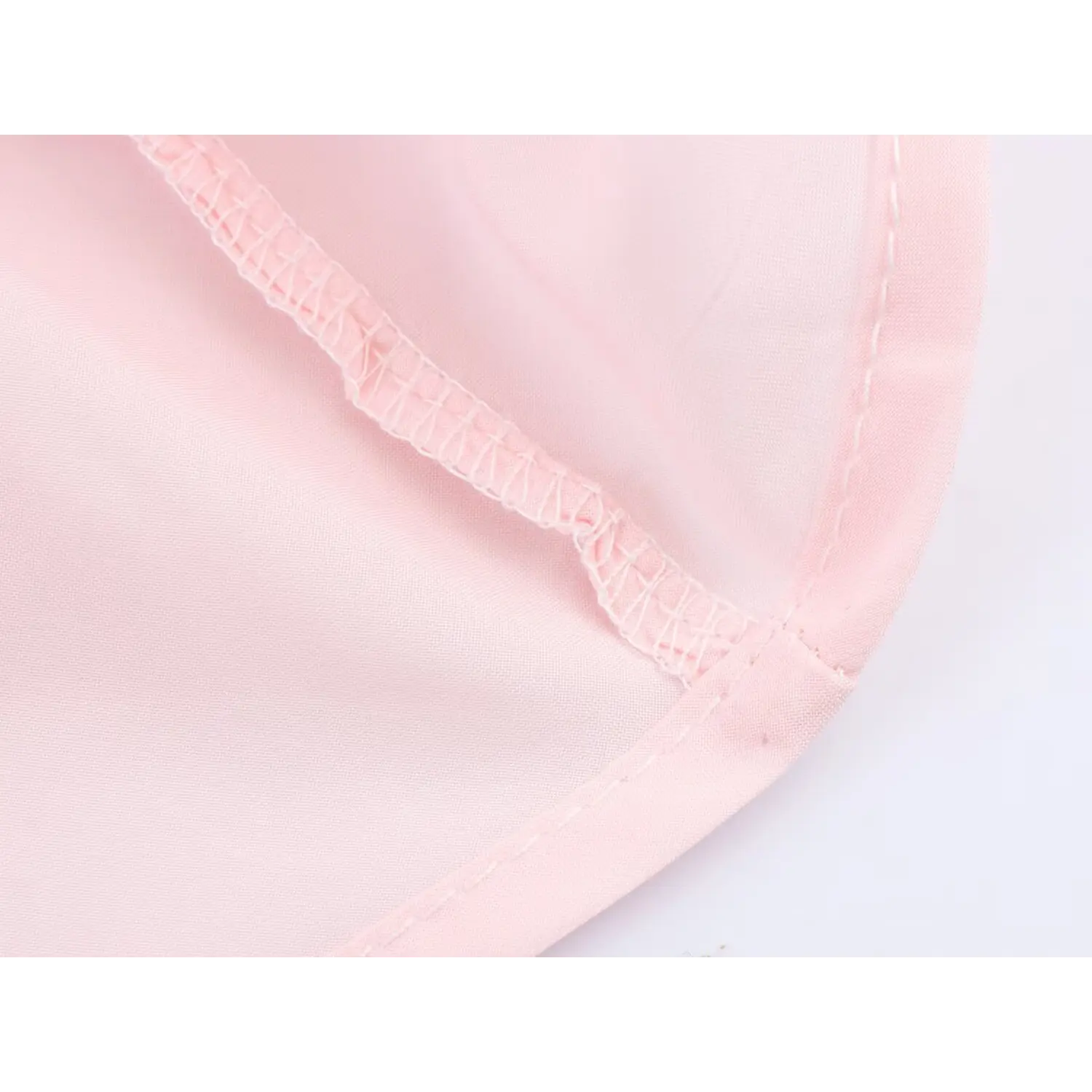 Interior close-up neat serged interlock overlock stitching, smooth solid pink lining connected to sheer outer chiffon fabric hem
