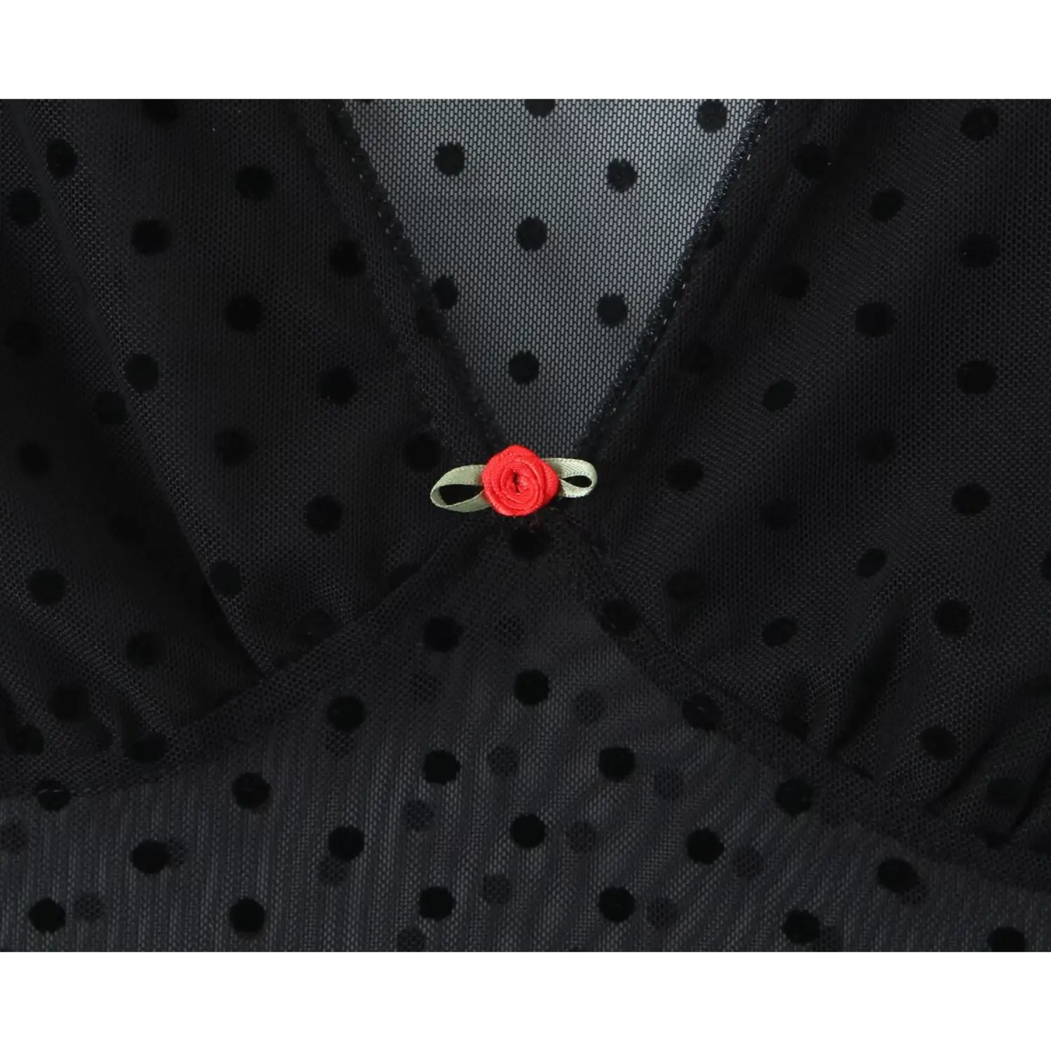 Close‑up small red rose bow ornament at v‑neck of black polka dot sheer mesh dress