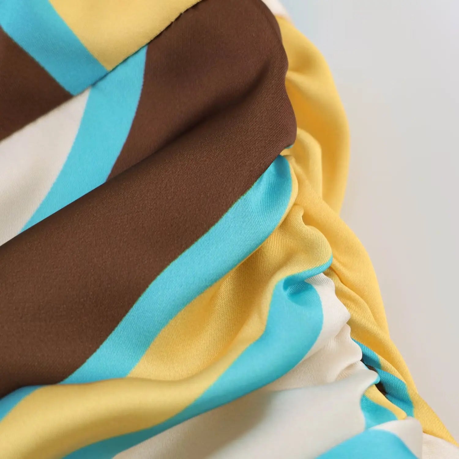 Close‑up of ruched waist section, abstract printed satin fabric folds