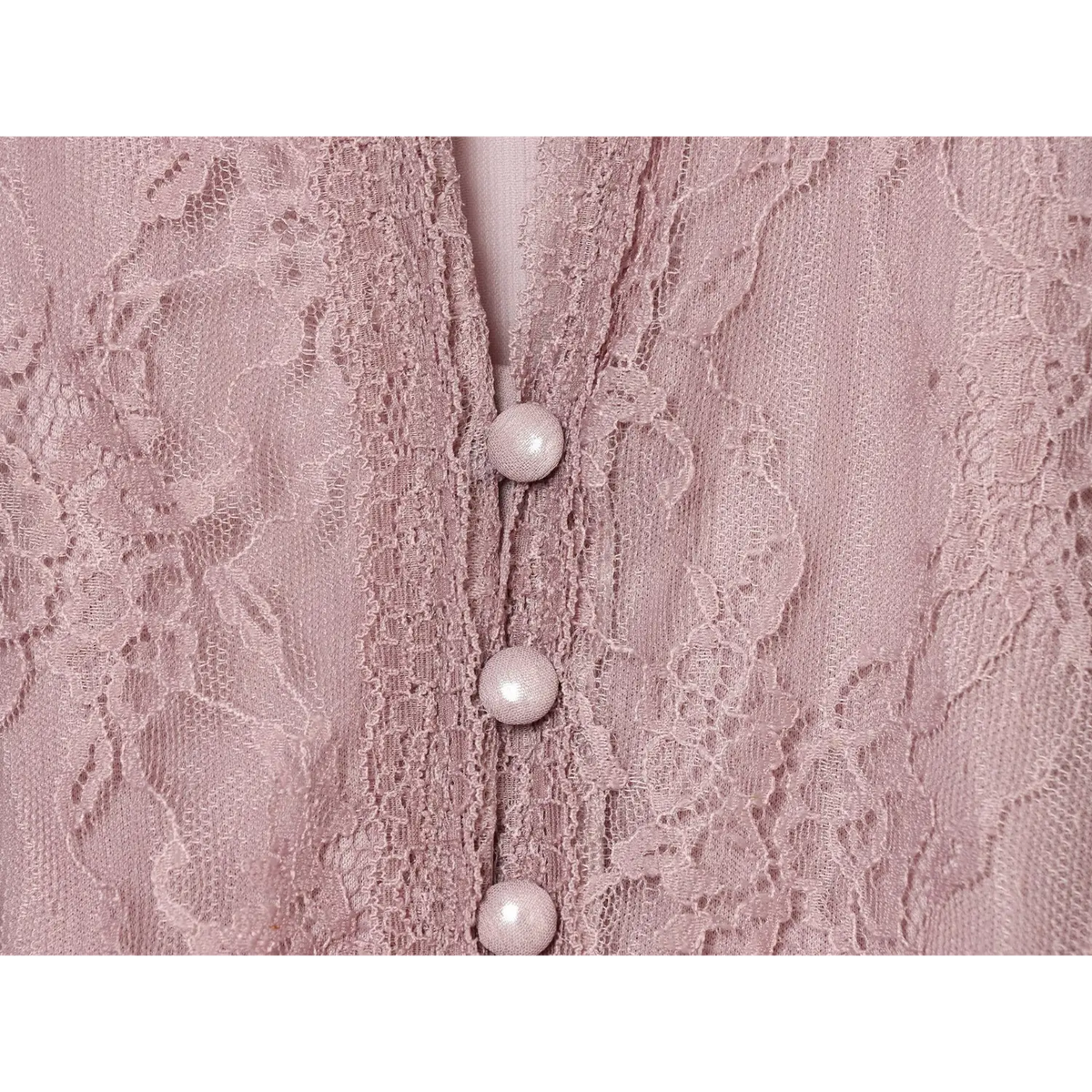 Close-up of pearl covered buttons on lace placket