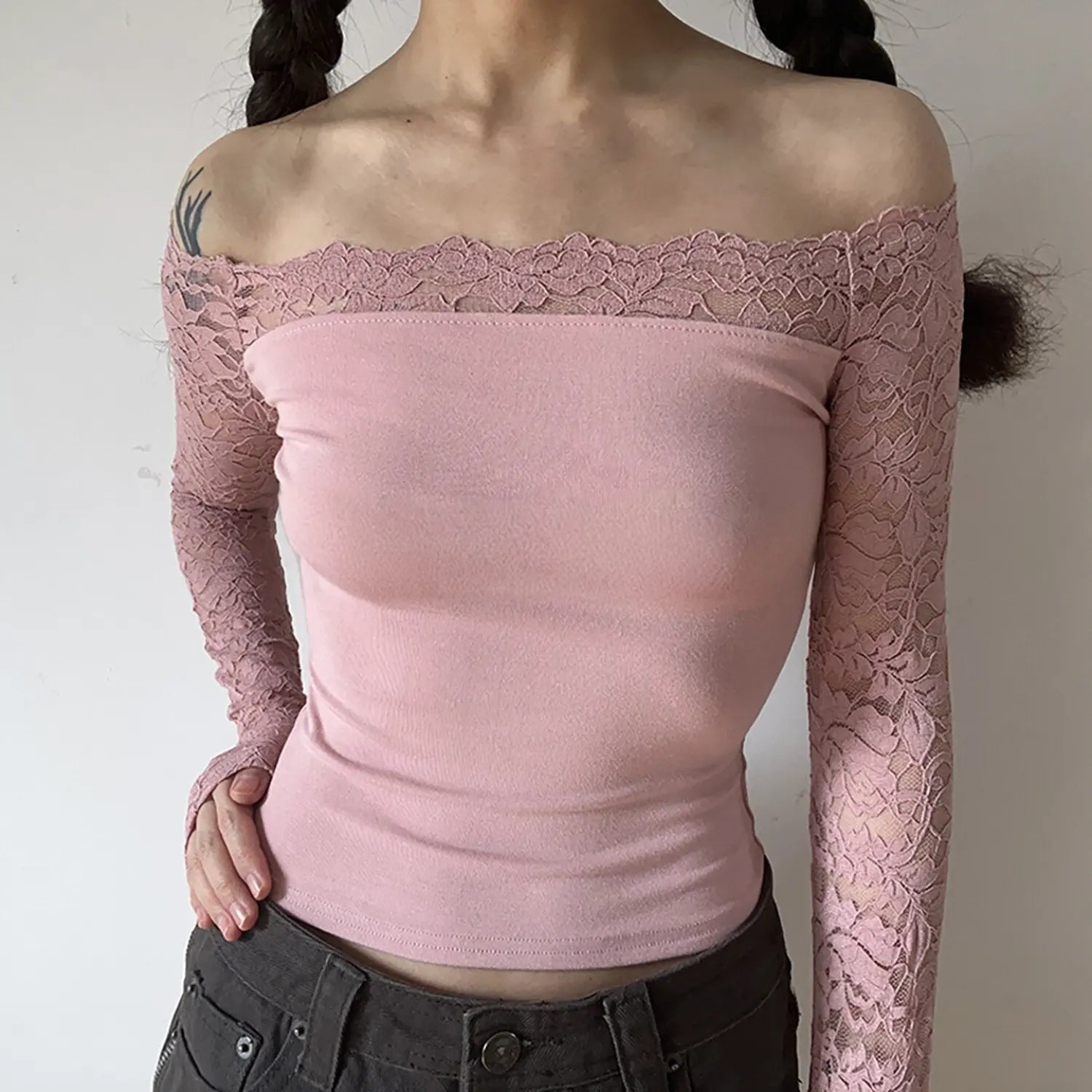 Model wearing dusty pink off‑shoulder lace long sleeve crop top, front pose