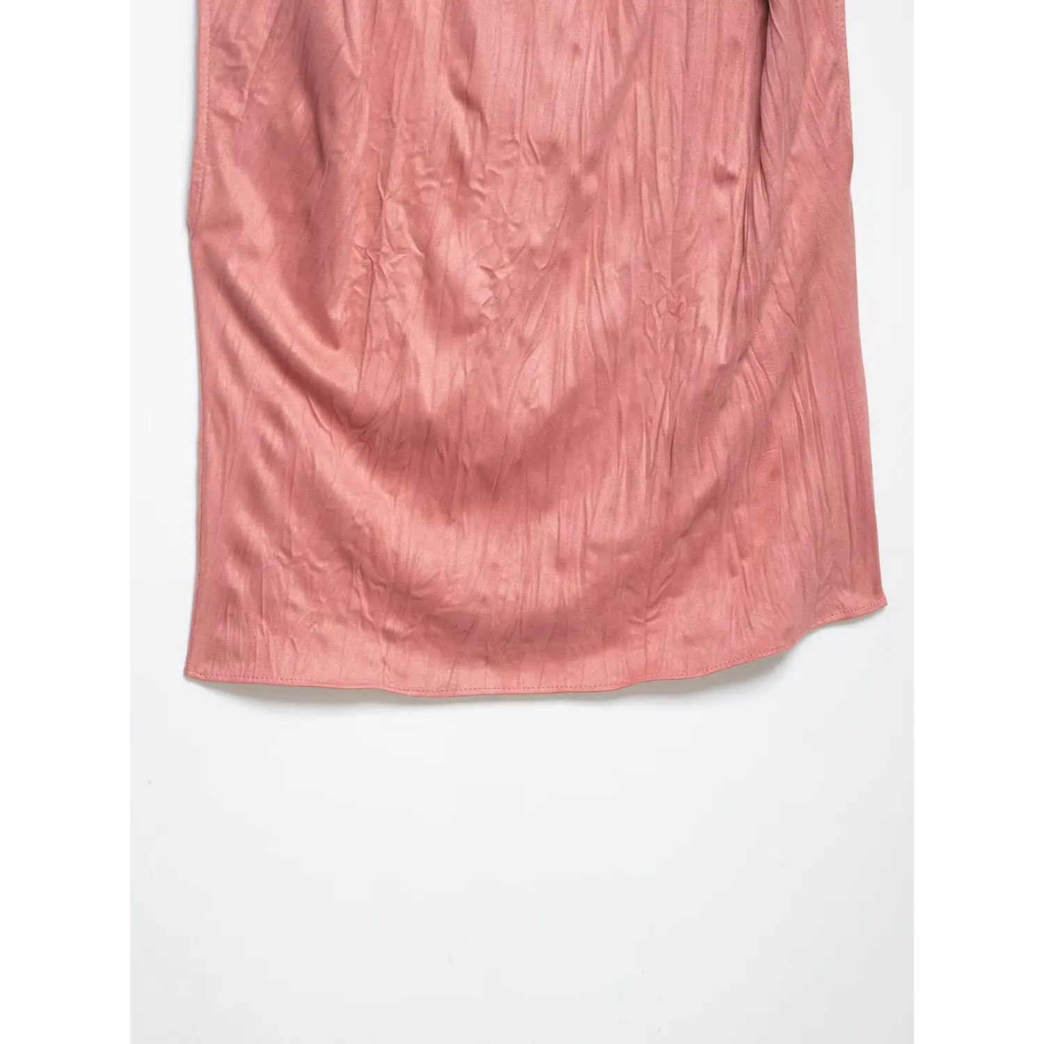 Macro shot of crinkled satin fabric texture at bottom hem on dusty rose twist shoulder top