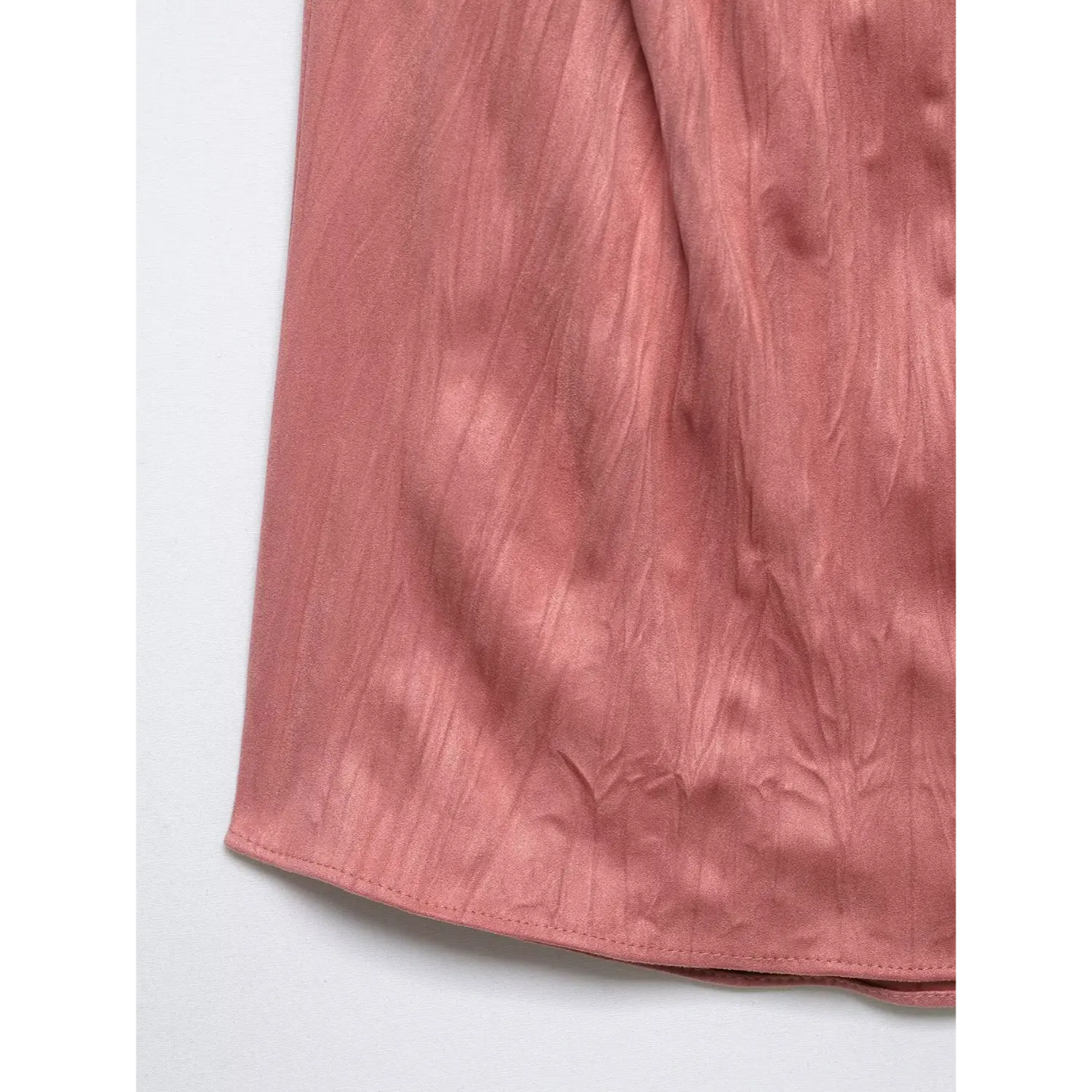 Close-up of bottom hem stitching and crinkled satin texture on dusty rose sleeveless top