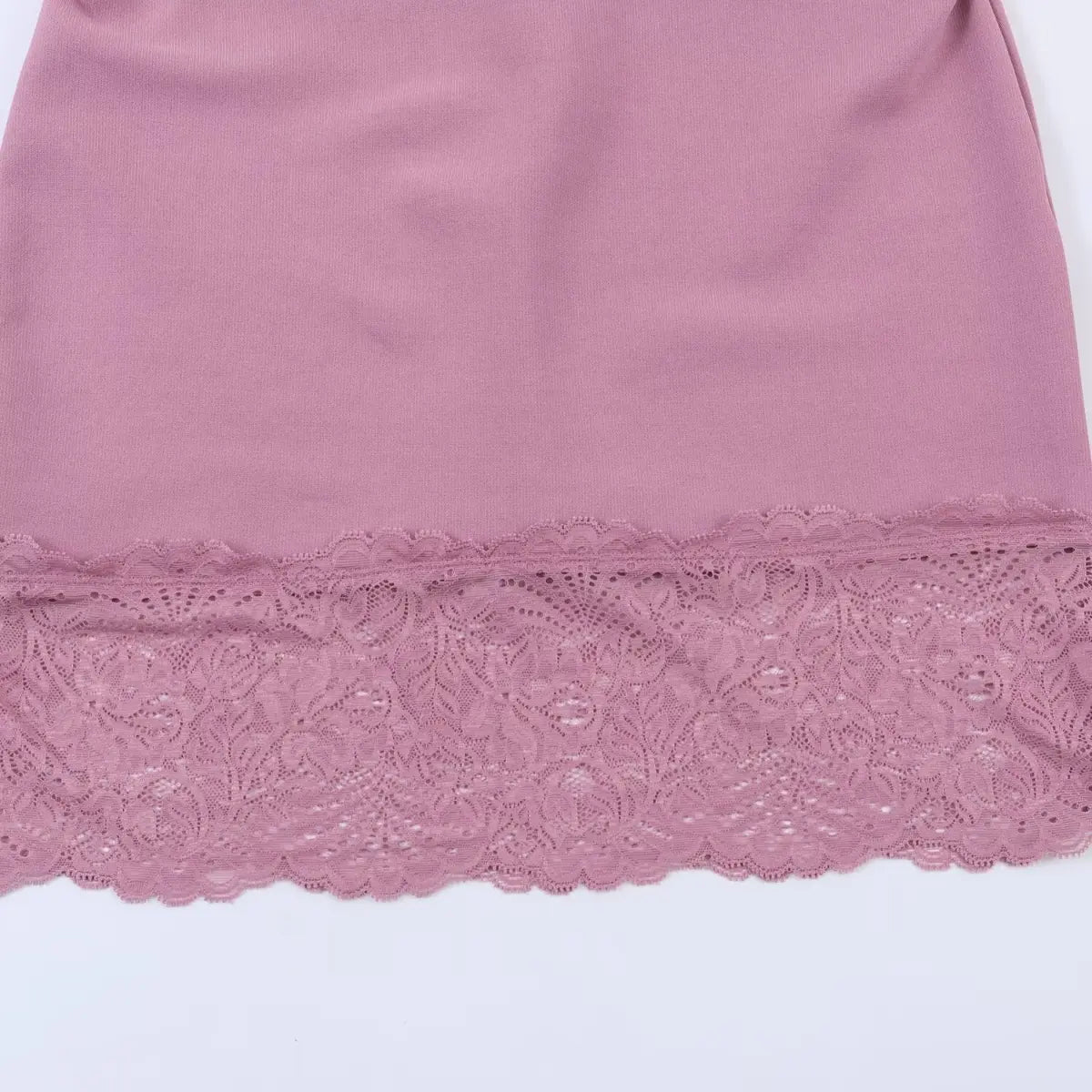 Close-up of the dress's hem, showcasing the intricate floral lace overlay with scalloped edges and matching dusty rose color.