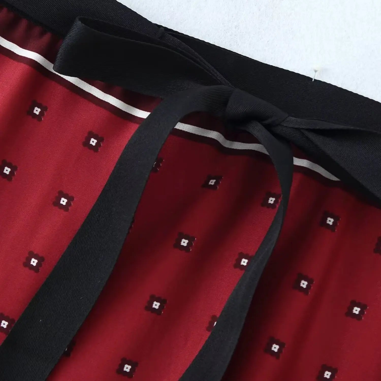 Macro shot of waist elastic top edge, neat stitching and wide black tie ribbon attachment