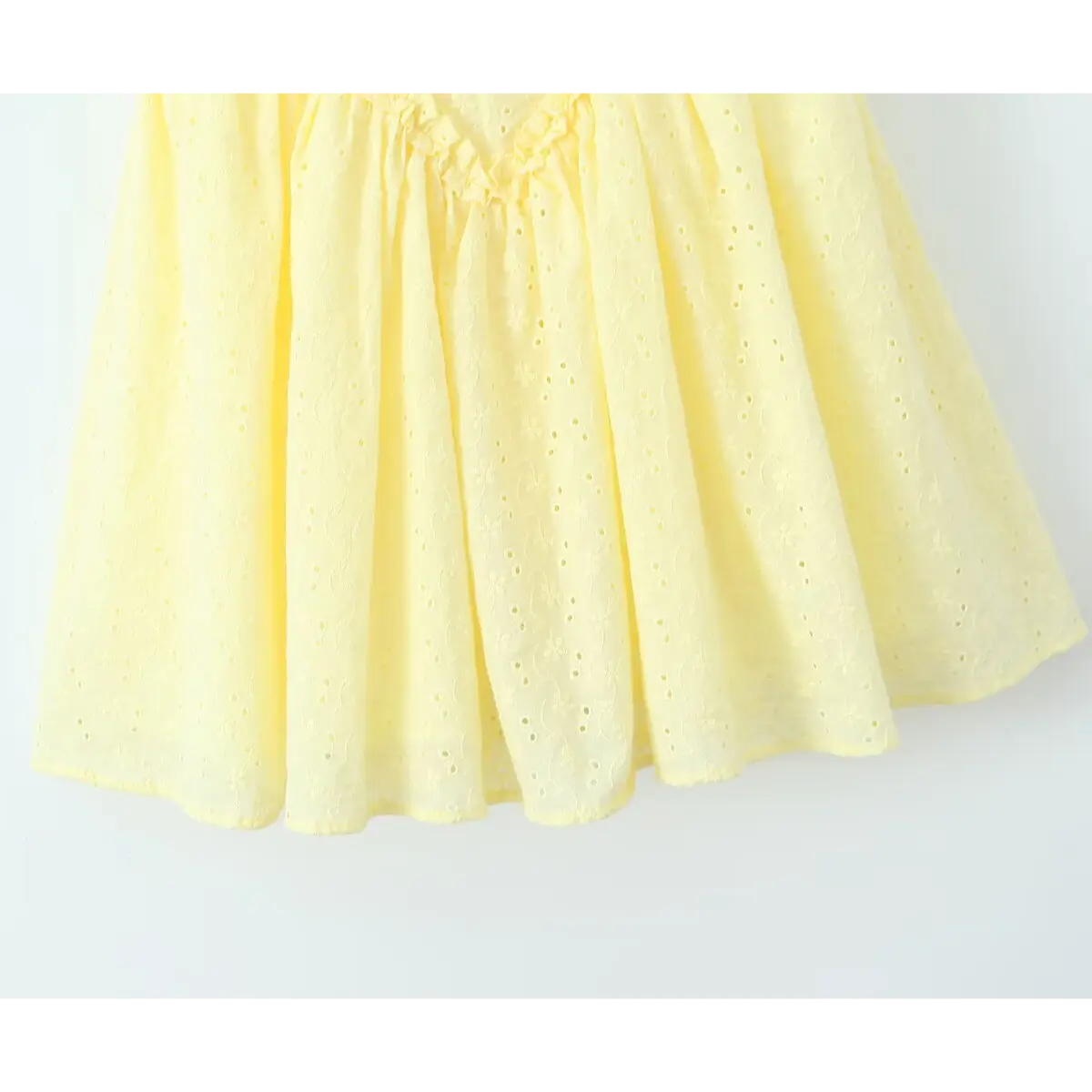 Skirt hem close, allover floral eyelet cutwork embroidery, gathered flare mini skirt edge on soft cotton fabric.