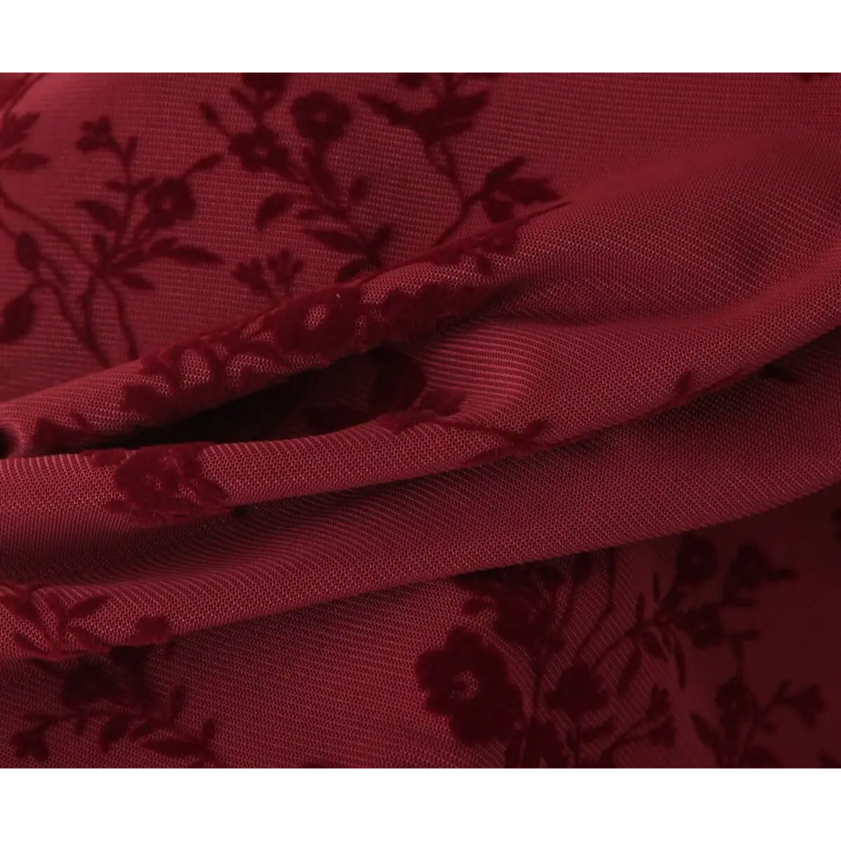 Close-up of the mesh fabric texture on a burgundy flocked floral dress, showing the sheer overlay and velvet-like floral flocking.